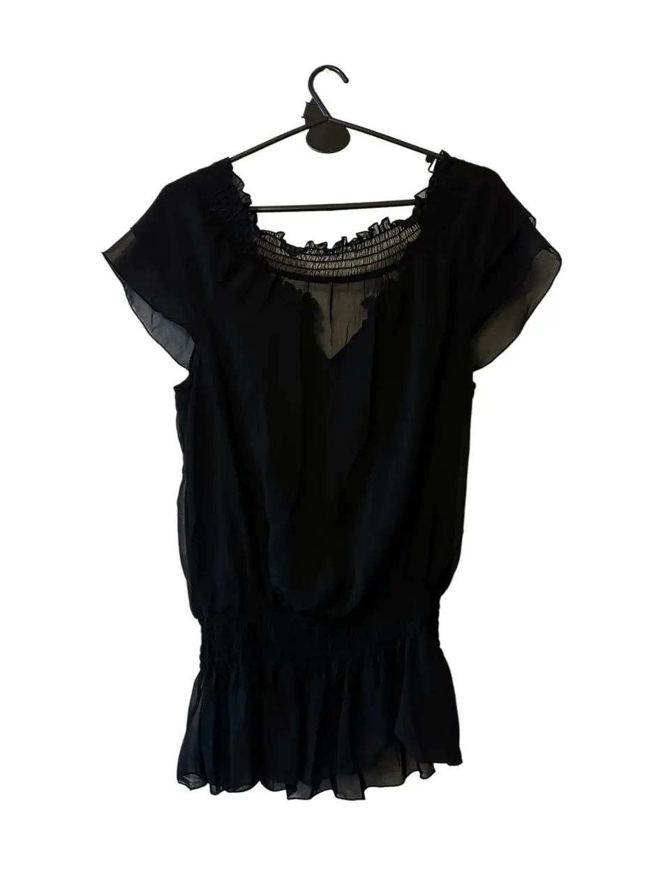 Blusa negra bordada, con detalles de volados y fruncidos. Ideal para una salida elegante o para darle un toque sofisticado a tu look diario.