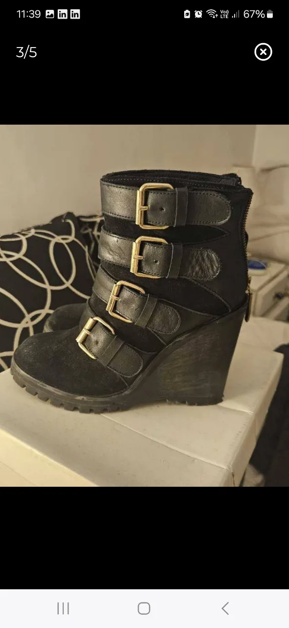 Botas negras de mujer con diseño de hebillas doradas y cuña. Ideales para un look moderno y audaz. Súper cómodas!