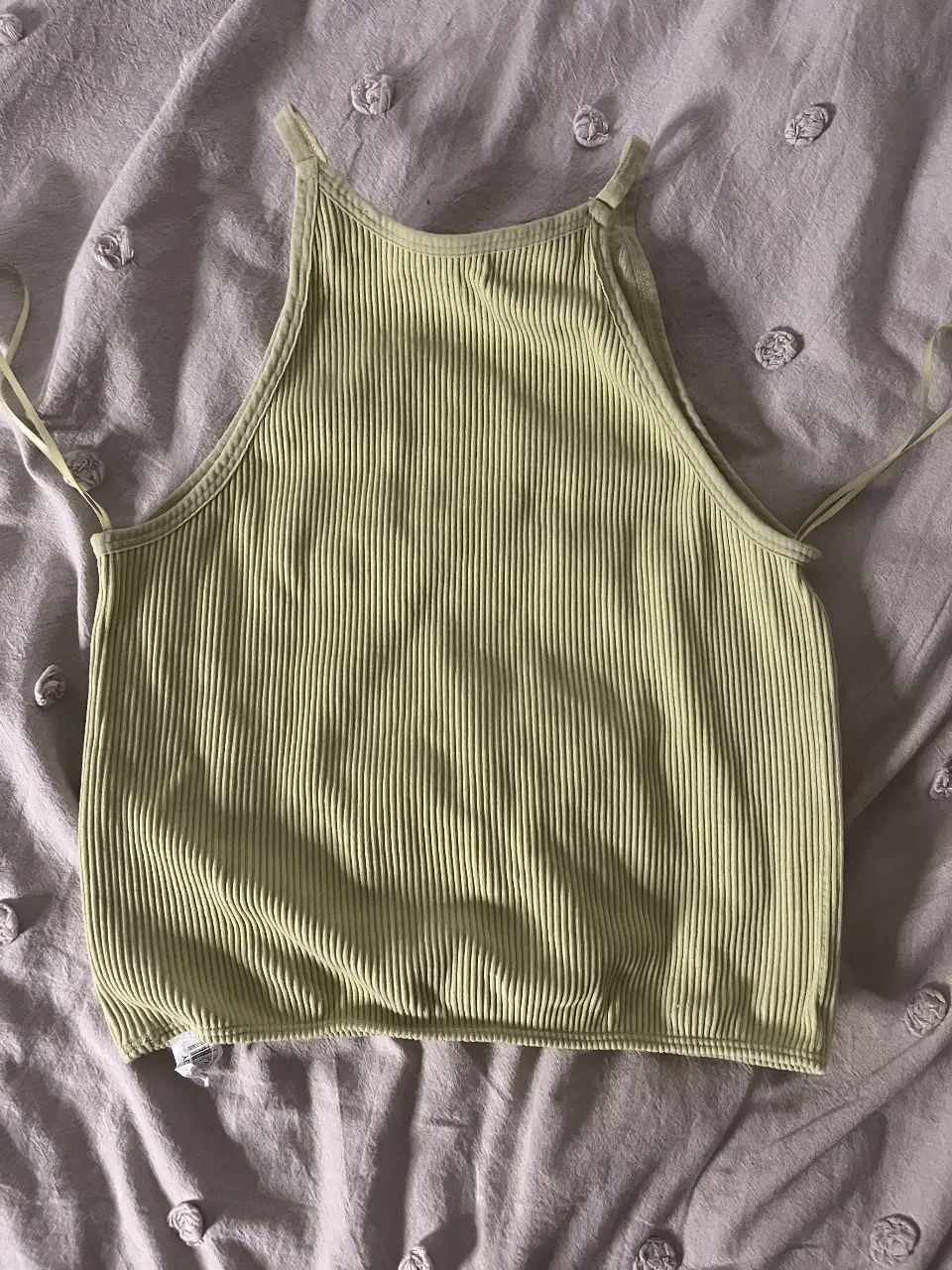 Top deportivo de color verde, sin mangas y con tirantes finos. Confeccionado en tejido de punto acanalado, ideal para actividades de bajo impacto. Marca Sybilla, talle M.