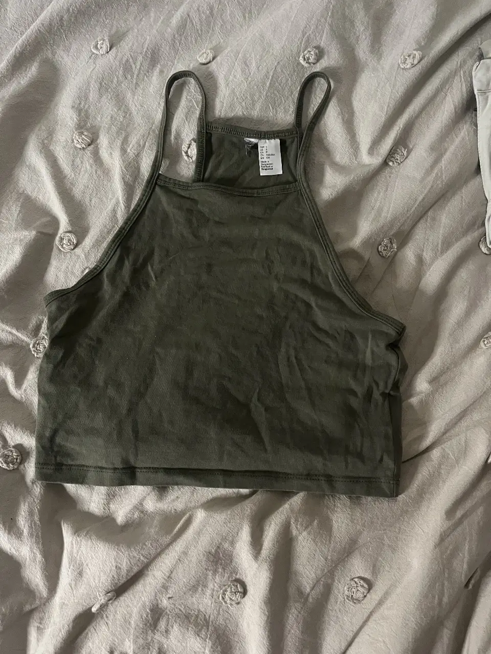 Top musculosa verde oscuro, con breteles finos y escote cuadrado. Ideal para un look casual y fresco.