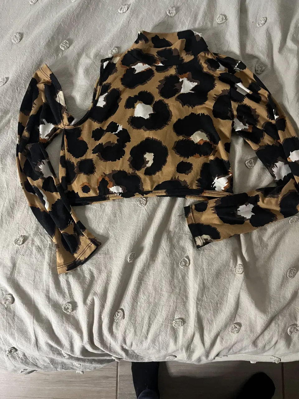 Top de mujer con estampado de leopardo, manga larga y cuello alto. Ideal para un look moderno y audaz. Perfecto para combinar con jeans o faldas.