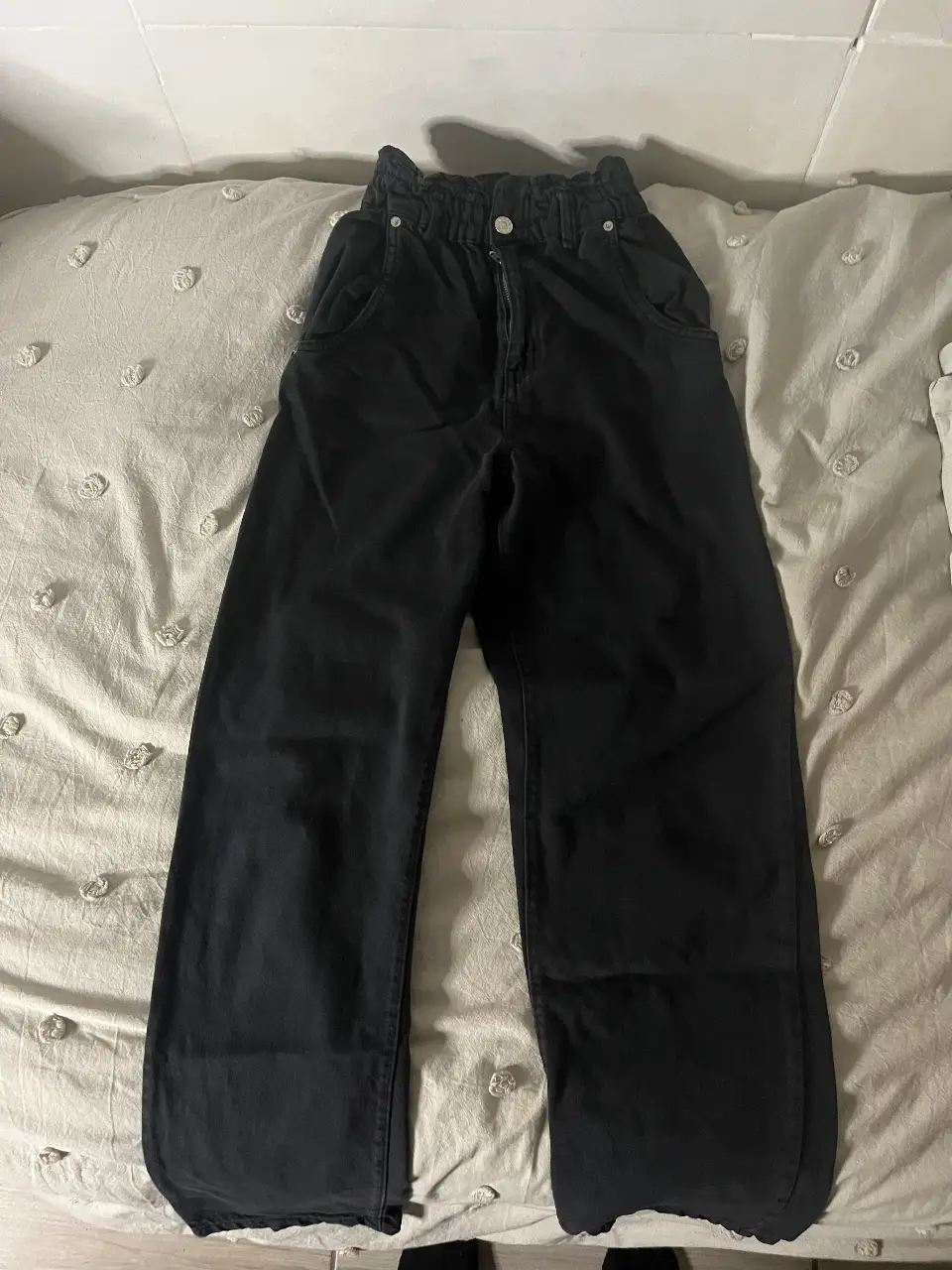 Pantalón negro de Pull&Bear, tiro alto, con cintura elastizada y corte amplio. Ideal para un look casual y cómodo.