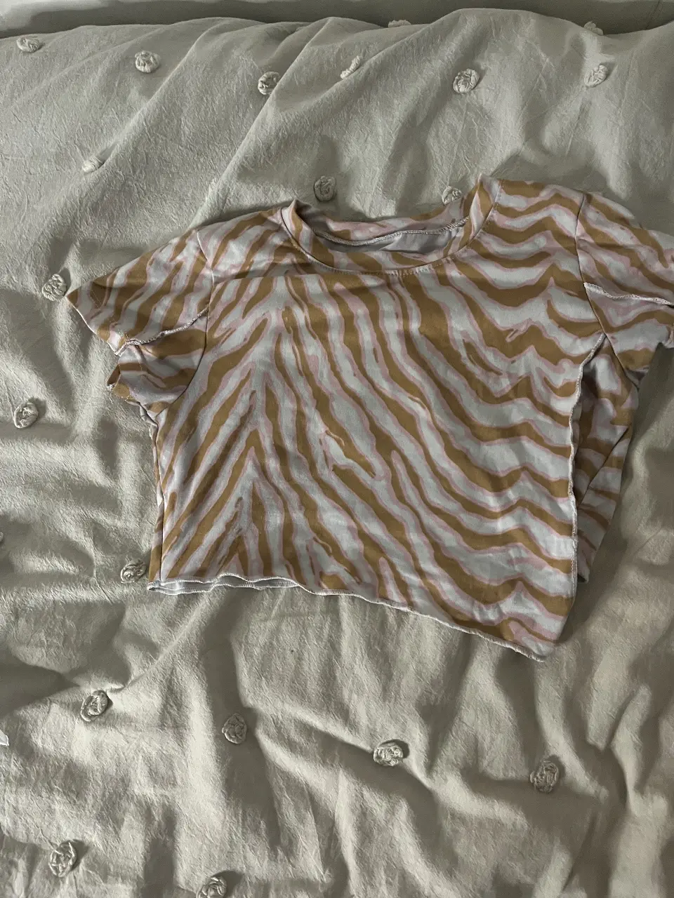 Remera crop con estampado de cebra en tonos marrones y blancos. Ideal para un look casual y moderno.