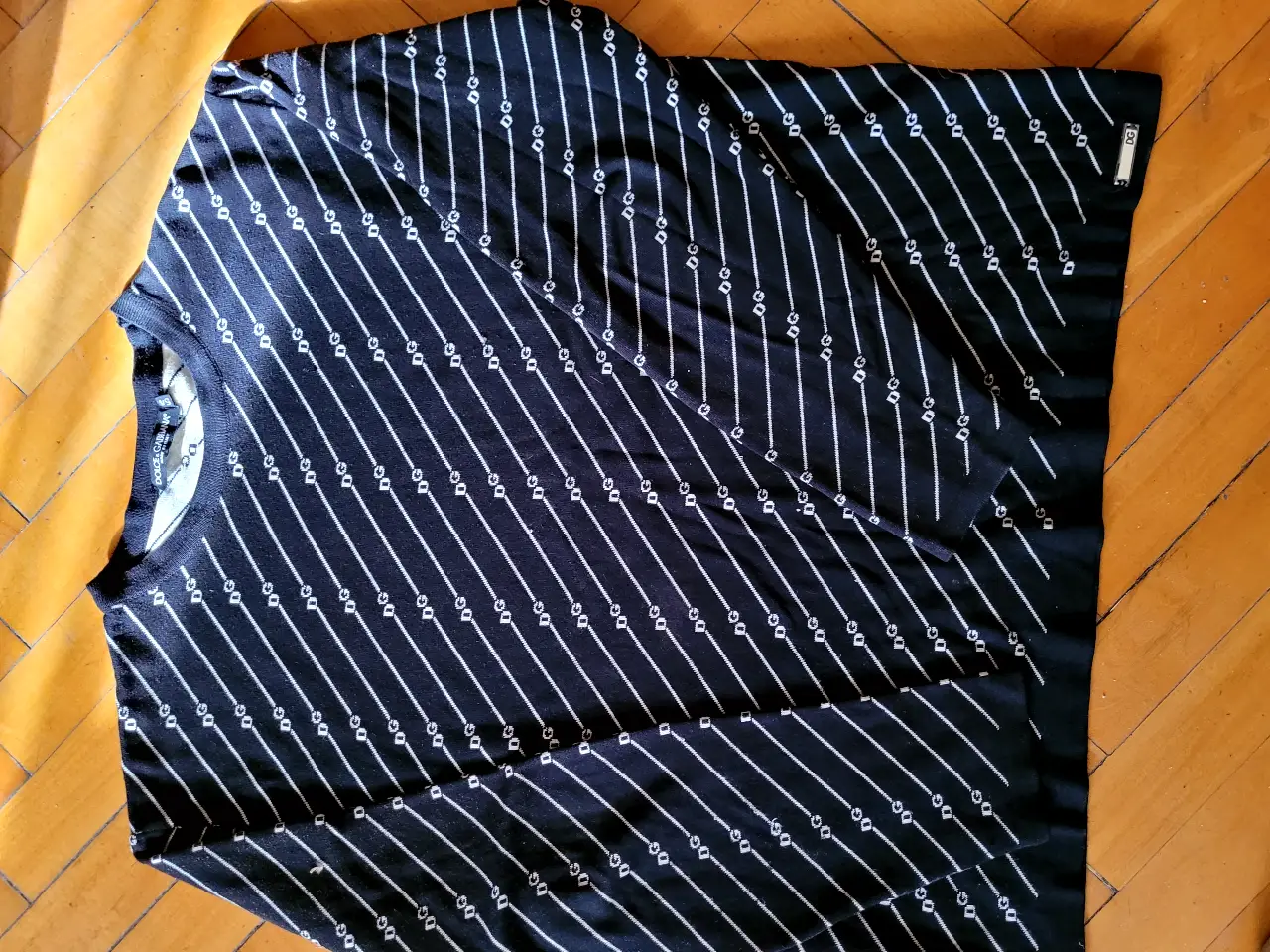 Sweater Dolce & Gabbana de hombre, negro con diseño de líneas blancas diagonales y detalles DG. Talle 54, Made in Italy. Ideal para un look elegante y sofisticado.