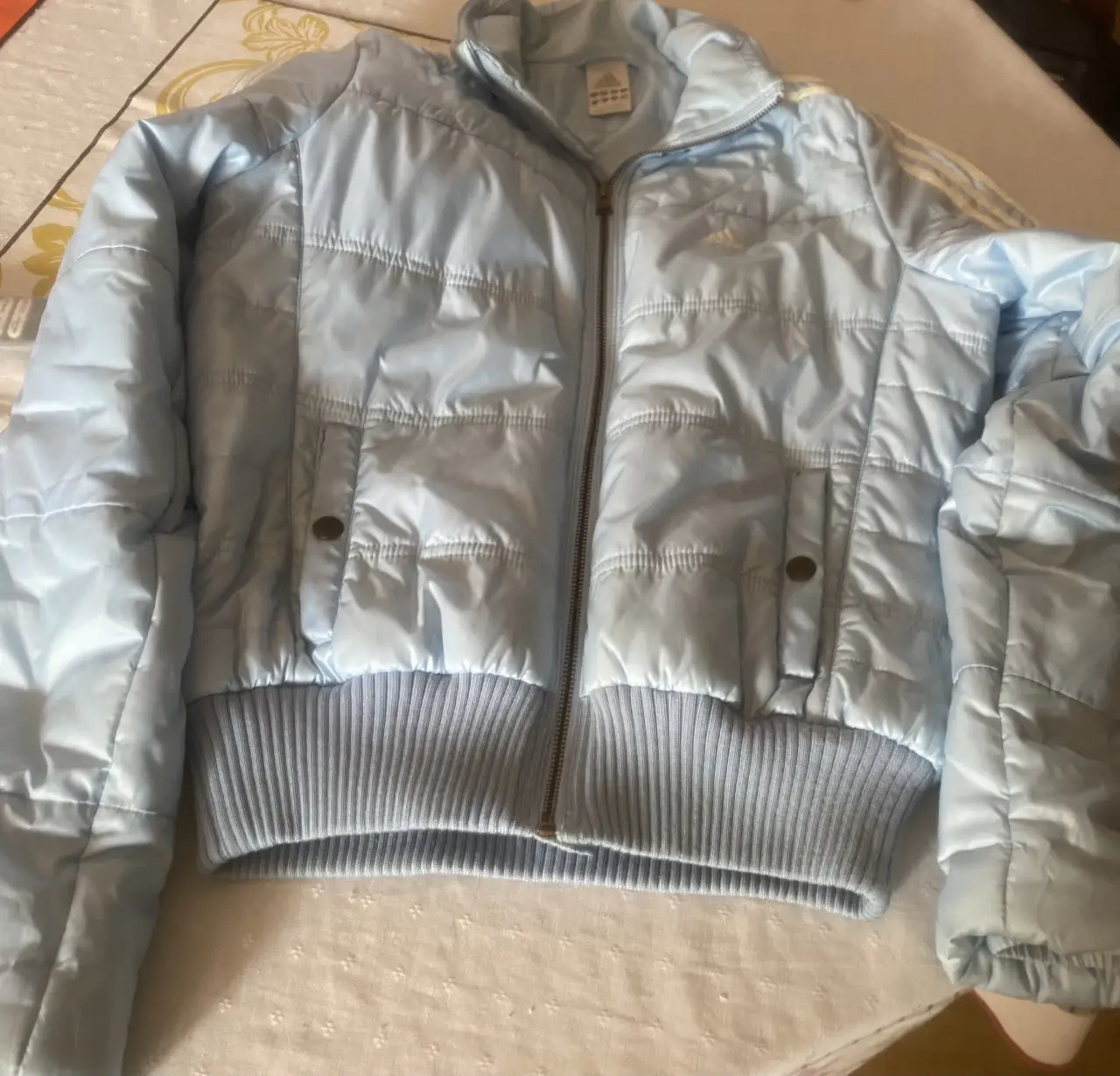Campera Adidas celeste, acolchada, con cierre y bolsillos. Ideal para el frío, cómoda y abrigada. Talle M.