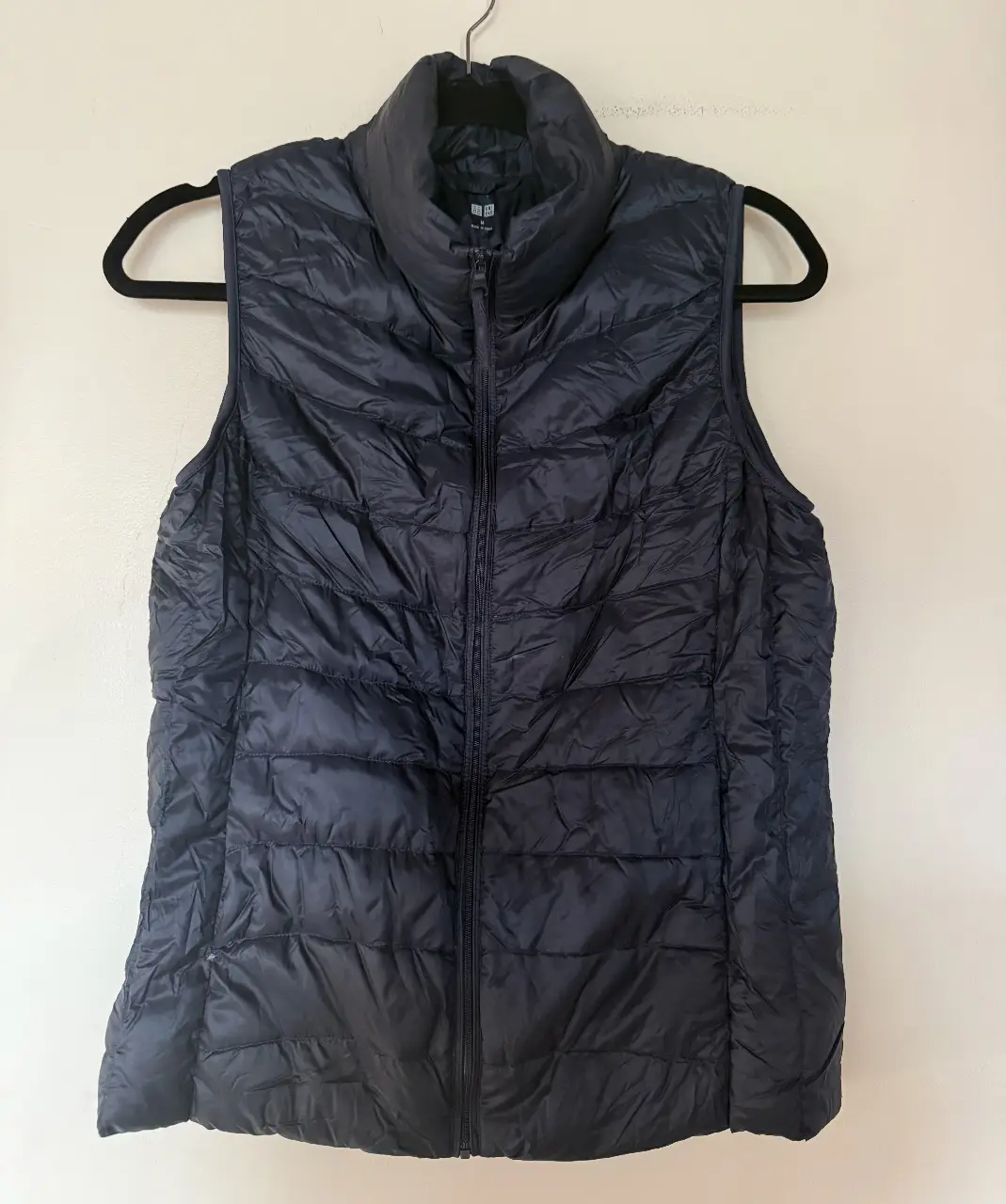 Chaleco acolchado azul marino de la marca Uniqlo, ideal para el invierno. Perfecto para usar en capas, este chaleco es ligero y abrigado, ideal para el día a día.