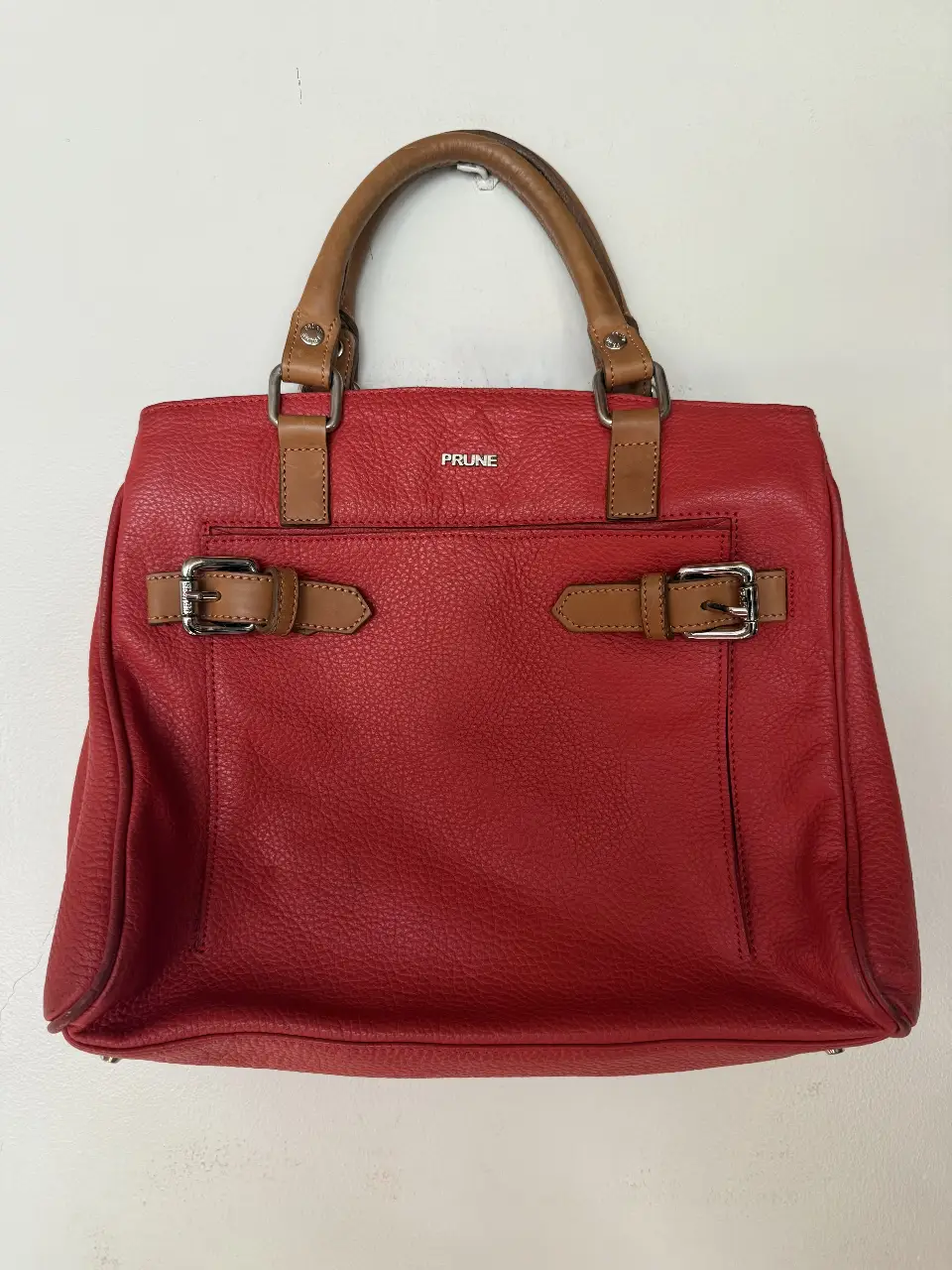 Cartera PRUNE roja de cuero con detalles marrones y hebillas. Ideal para un look elegante y sofisticado.