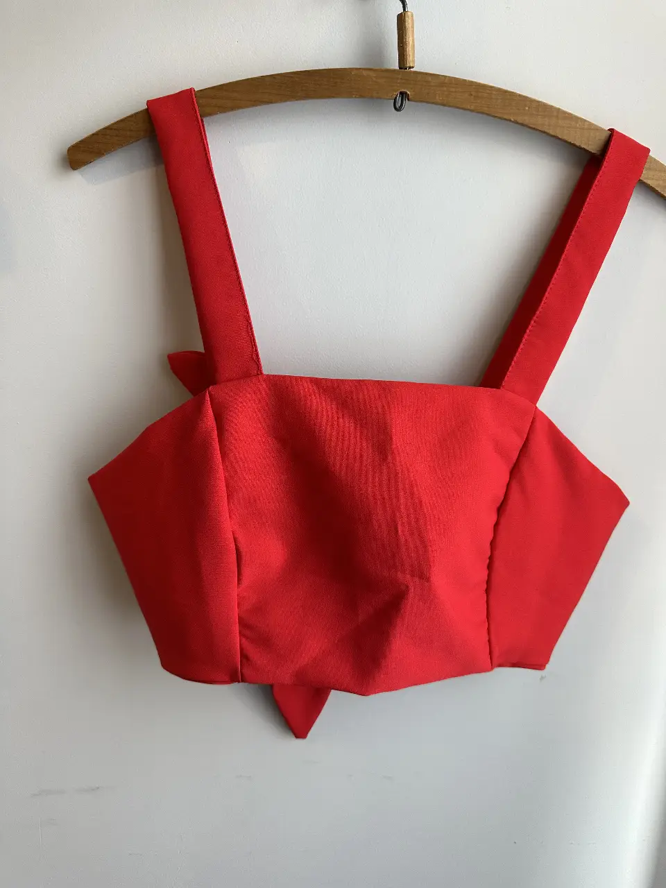 Top rojo con lazo en la cintura y tirantes anchos. Ideal para un look moderno y femenino.