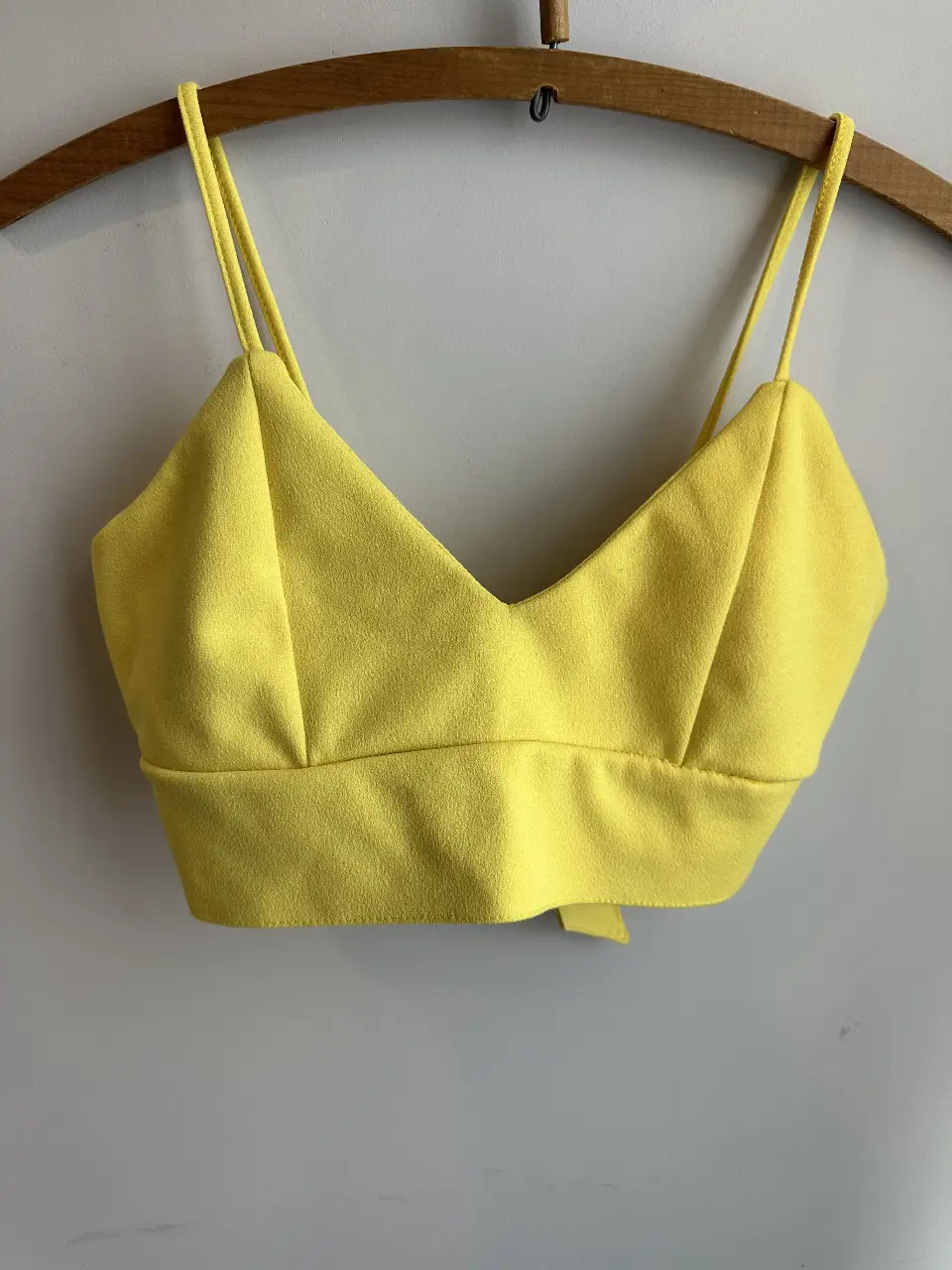 Top amarillo con breteles finos y detalle de moño en la espalda. Ideal para un look fresco y moderno.