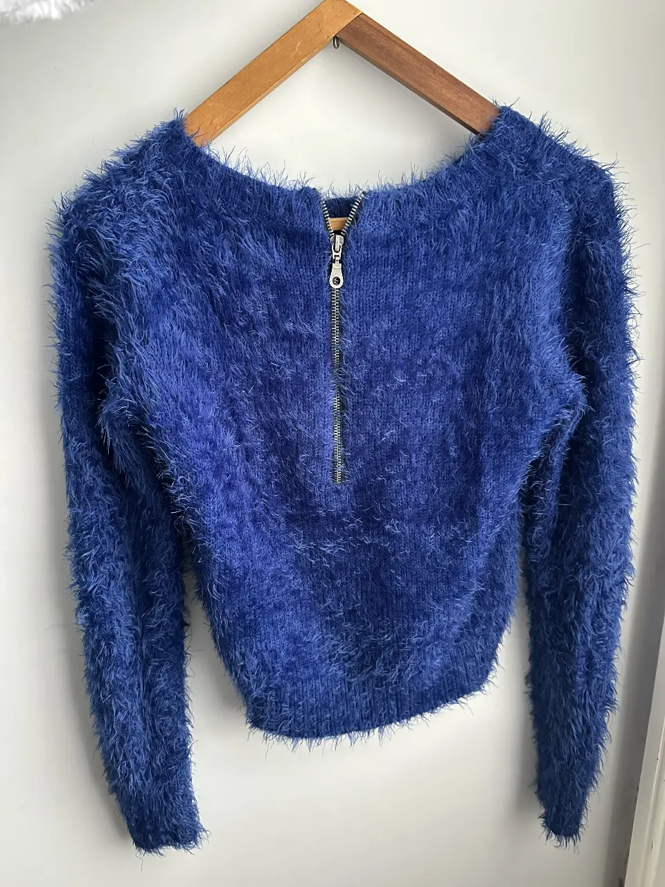 Sweater azul con cierre frontal, tejido peludo. Ideal para un look moderno y abrigado.