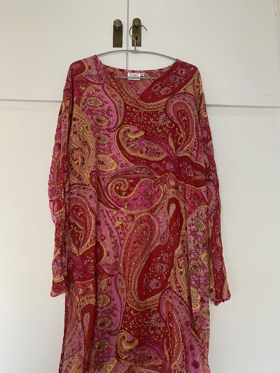 Vestido largo de mujer con estampado paisley en tonos rojos y rosas. Ideal para un look bohemio y elegante.