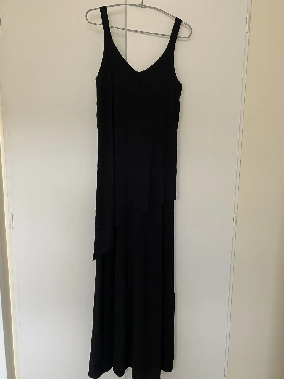 Vestido largo negro con breteles finos y detalle de volado en la parte delantera. Ideal para eventos formales o salidas nocturnas.
