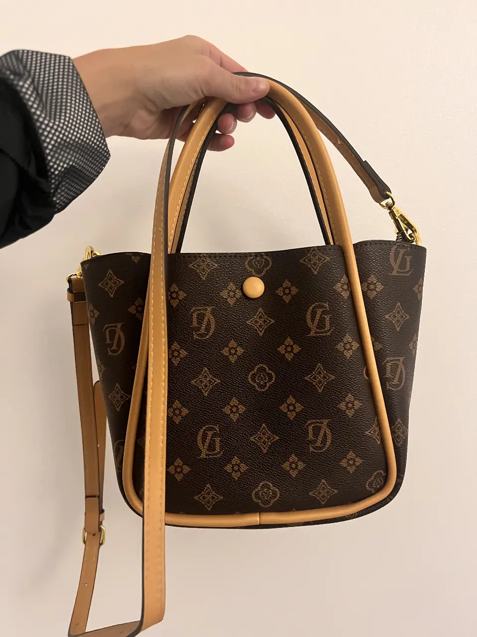 réplica exacta comprada en Hong Kong sin uso. Cartera tipo tote bag marrón con estampado de monograma. Cuenta con manijas cortas y una correa larga desmontable. Ideal para un look casual y elegante.