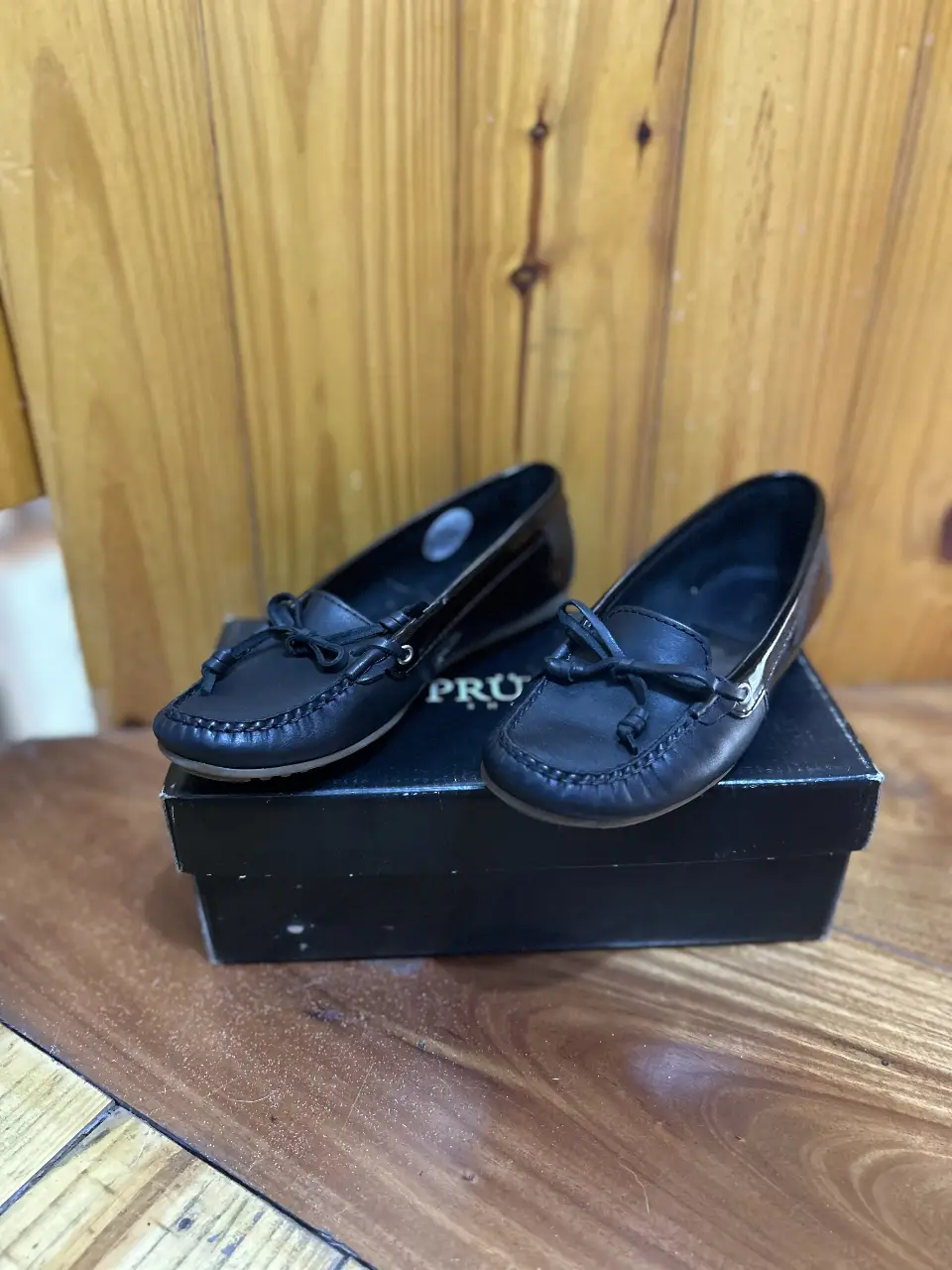 Mocasines de cuero negro para mujer. Diseño clásico con moño en la parte delantera. Ideales para un look casual y elegante.