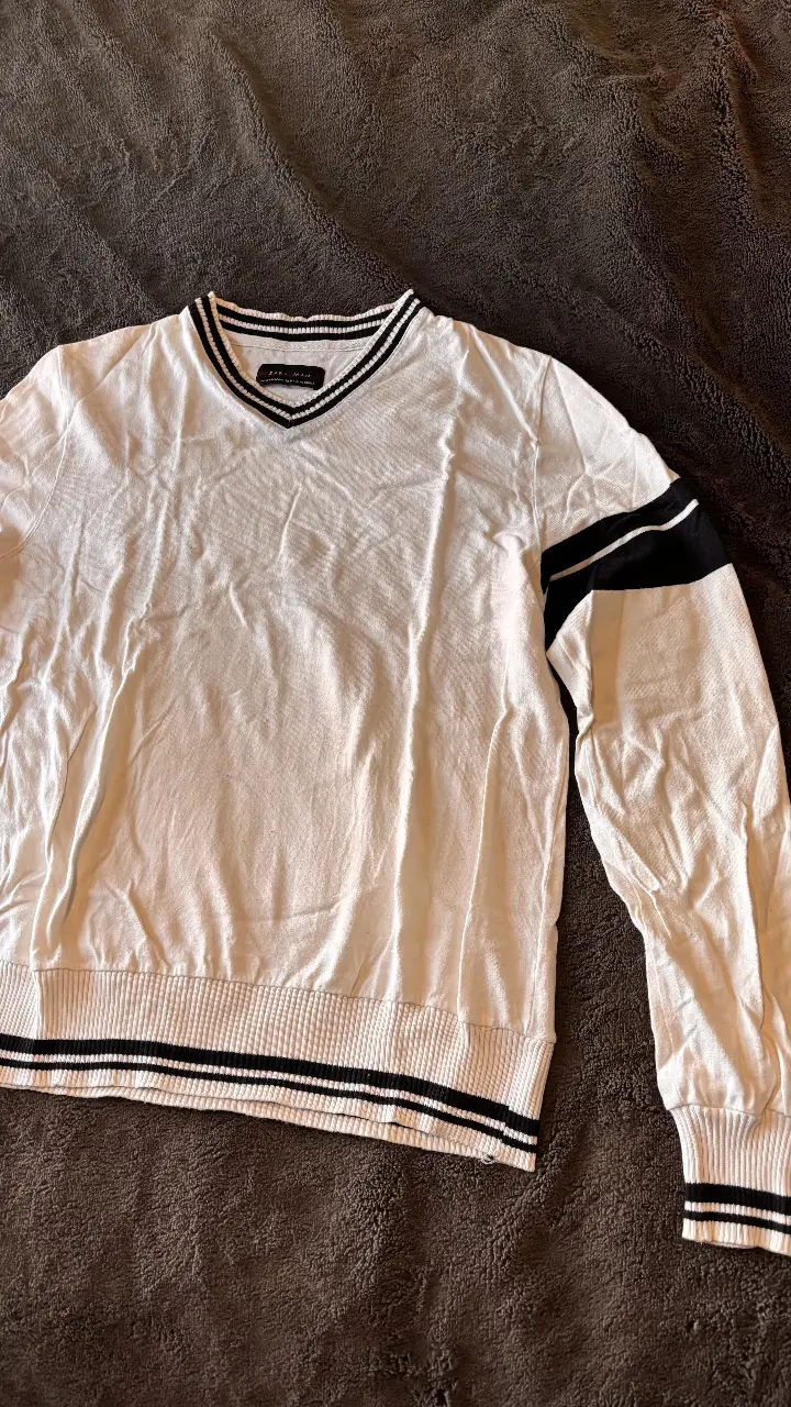 Sweater de hombre Zara Man blanco con detalles en negro. Cuello en V y mangas largas con detalles de rayas negras. Talle M.