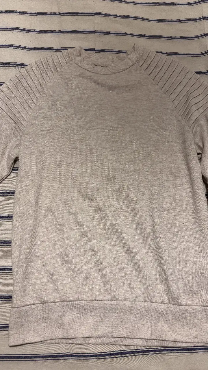 Buzo de cuello redondo, color beige claro. Detalles en los hombros. Talle S. Marca Primark. Ideal para un look casual y cómodo.