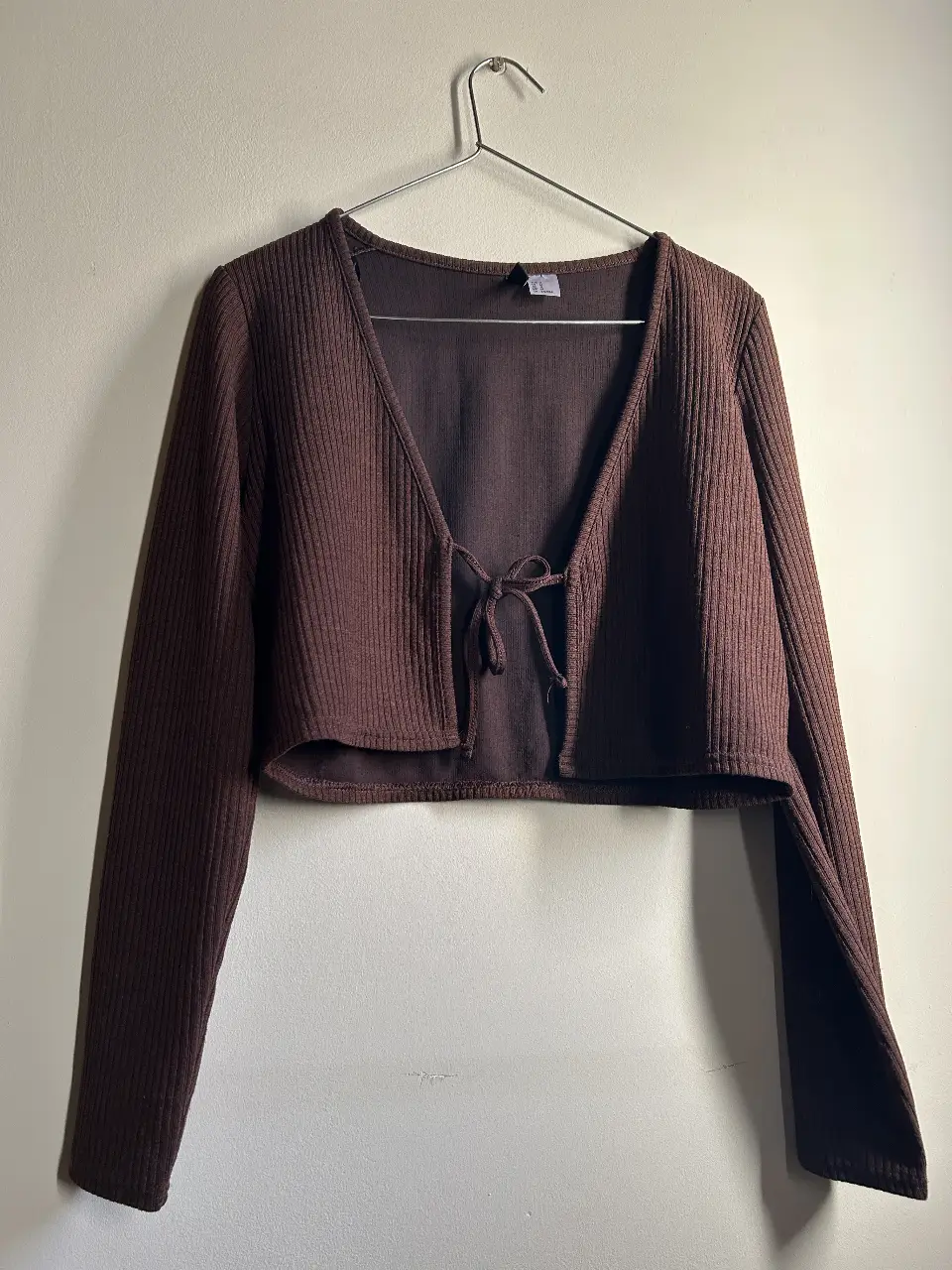 Cardigan H&M  marrón de tejido acanalado con detalle de lazo en la cintura. Ideal para un look casual y cómodo.