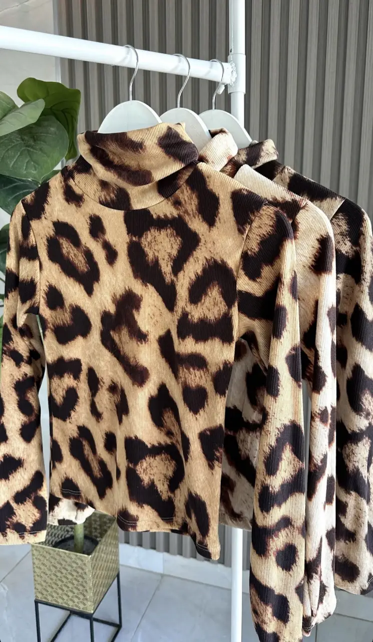 Remera de manga larga con cuello alto y estampado de leopardo. Ideal para un look audaz y moderno.