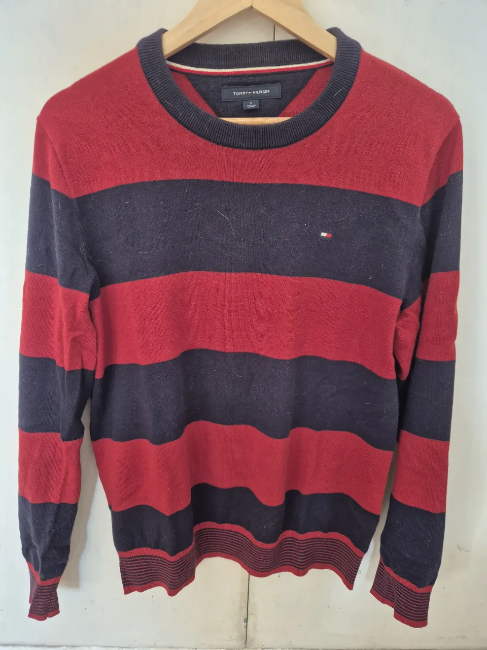 Sweater Tommy Hilfiger a rayas horizontales en rojo y azul marino. Cuello redondo y logo bordado en el pecho. Ideal para un look casual y abrigado. Talle M muy poco uso.