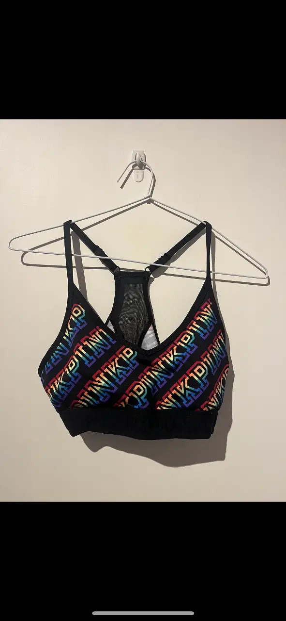 Corpiño deportivo PINK con estampado del logo en arcoíris. Ideal para entrenamientos de alto impacto, ofrece soporte y estilo.