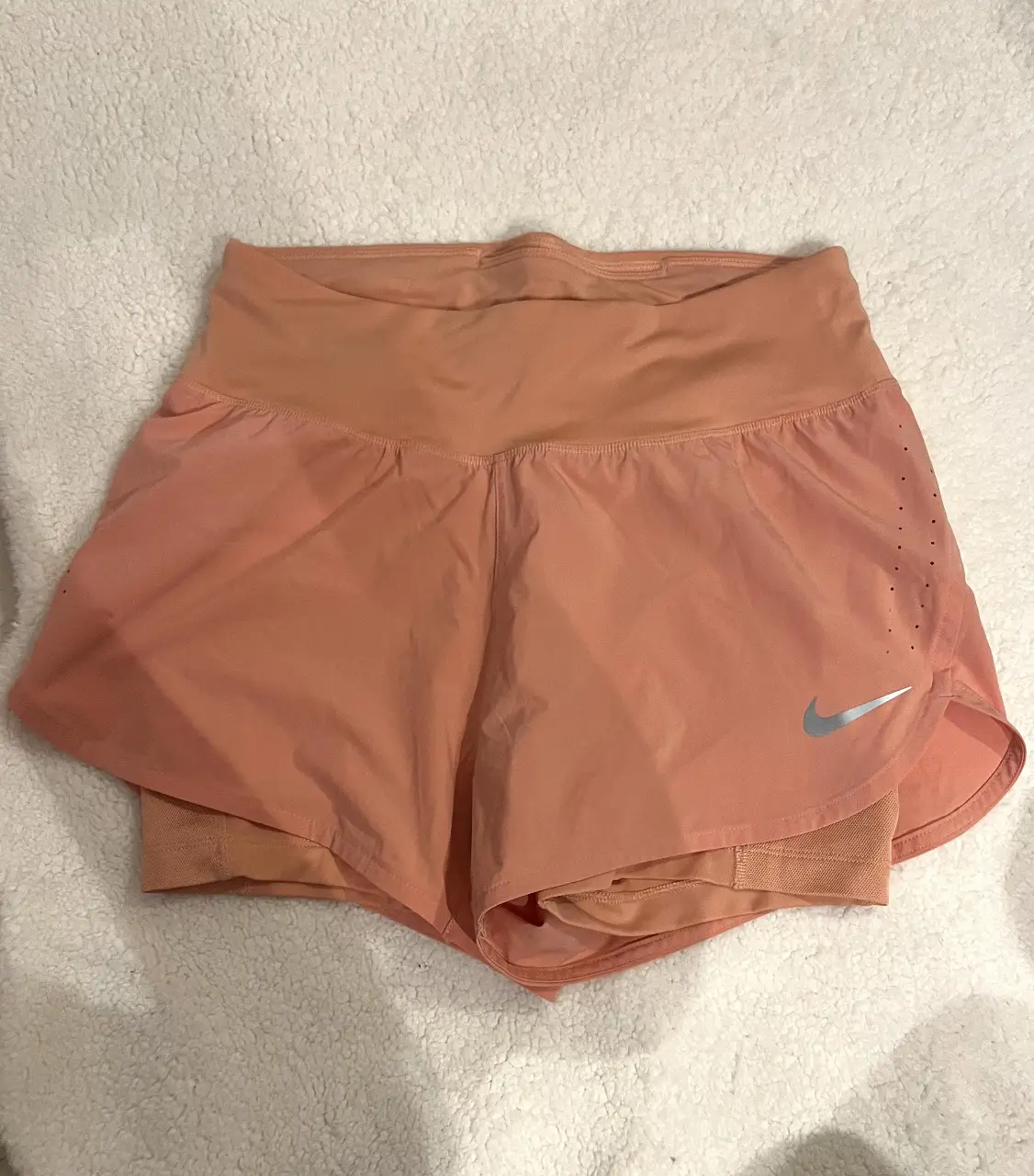 Short deportivo de running para mujer, color durazno (piel rosa) , con calza interior y detalles de ventilación. Ideal para tus entrenamientos. Talle S
