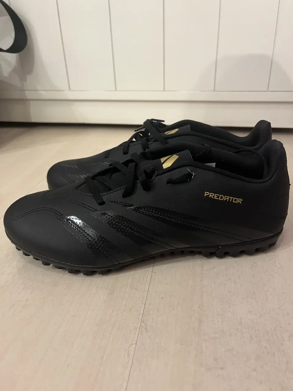 Zapatillas de fútbol Adidas Predator, color negro con detalles dorados. Talle 38,5 , ideales para jugar en césped sintético. Diseño moderno y ajuste perfecto para un mejor rendimiento en la cancha.