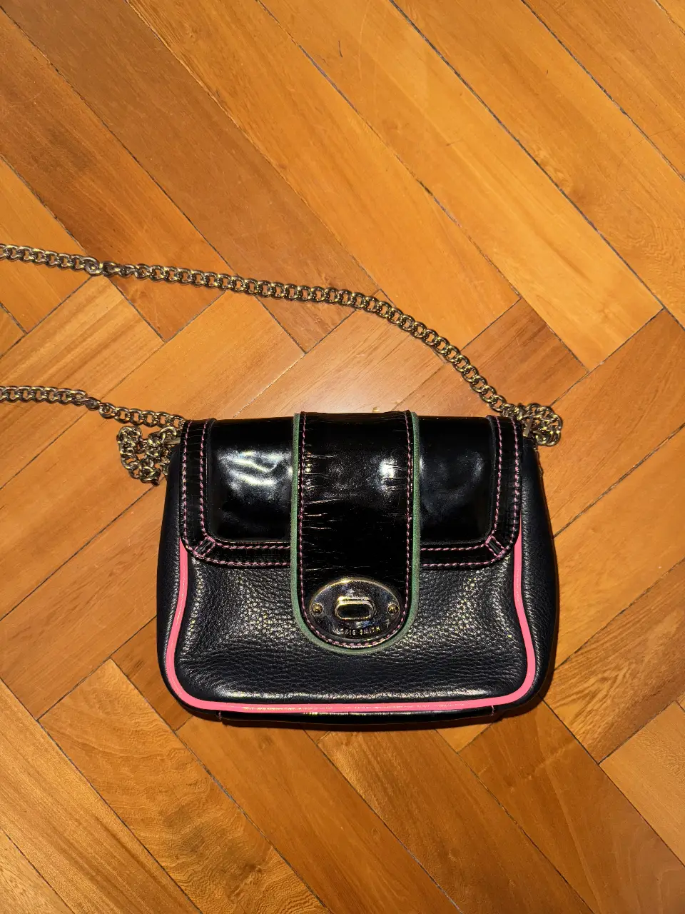 Bandolera negra JACKIE SMITH original usada con detalles en rosa y verde. Ideal para llevar lo esencial con estilo. Perfecta para salidas y eventos.