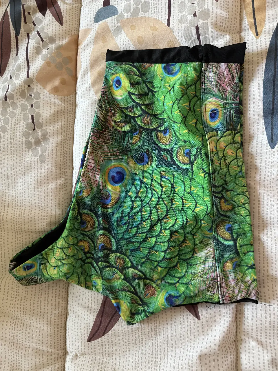top  con estampado de plumas de pavo real. Ideal para actividades físicas o para un look casual y llamativo.