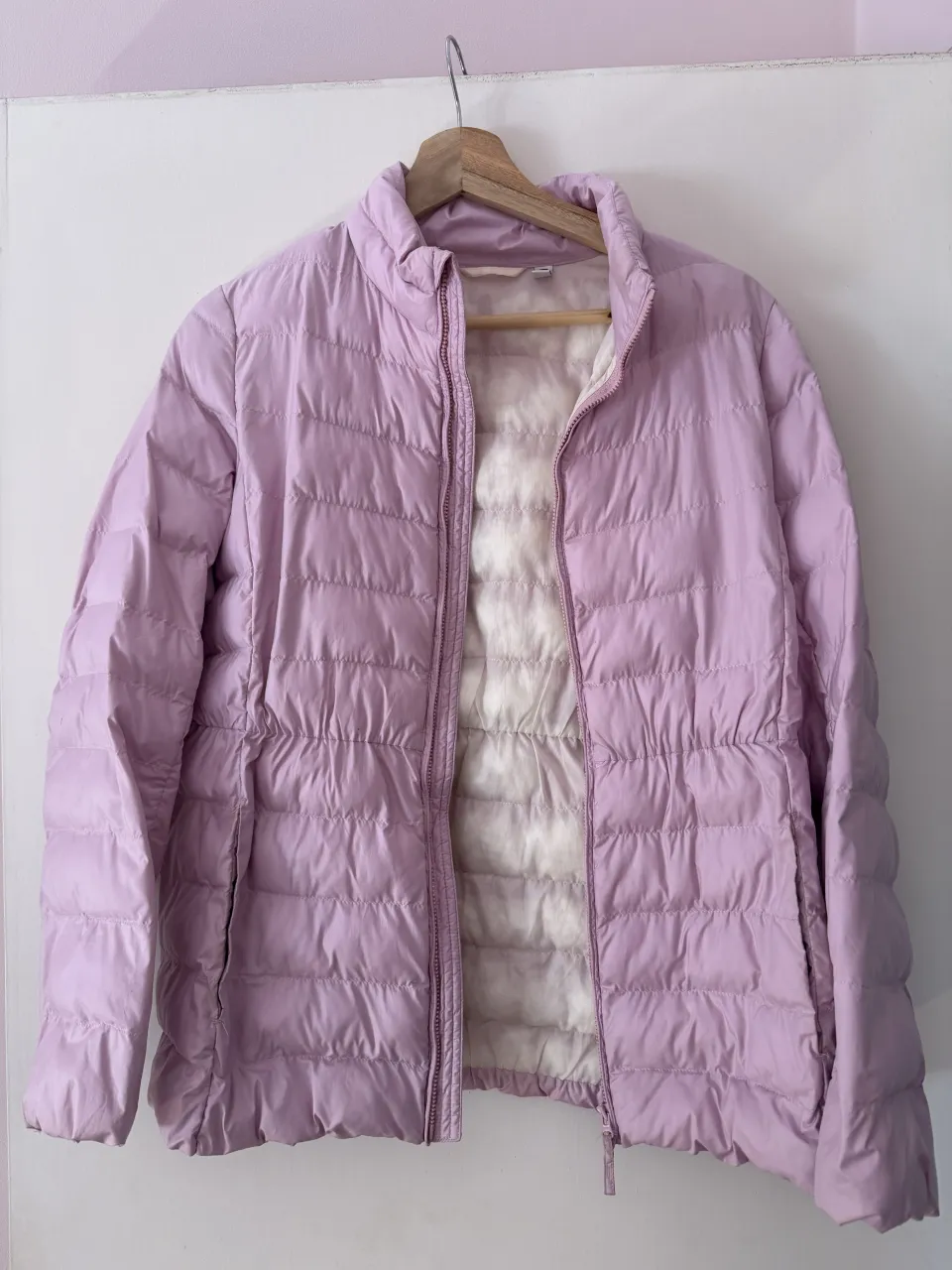 Campera acolchada liviana en color lila, ideal para el entretiempo o para usar como capa extra en invierno. Tiene cierre al frente y un diseño moderno que se ajusta a la cintura. Perfecta para un look casual y cómodo.