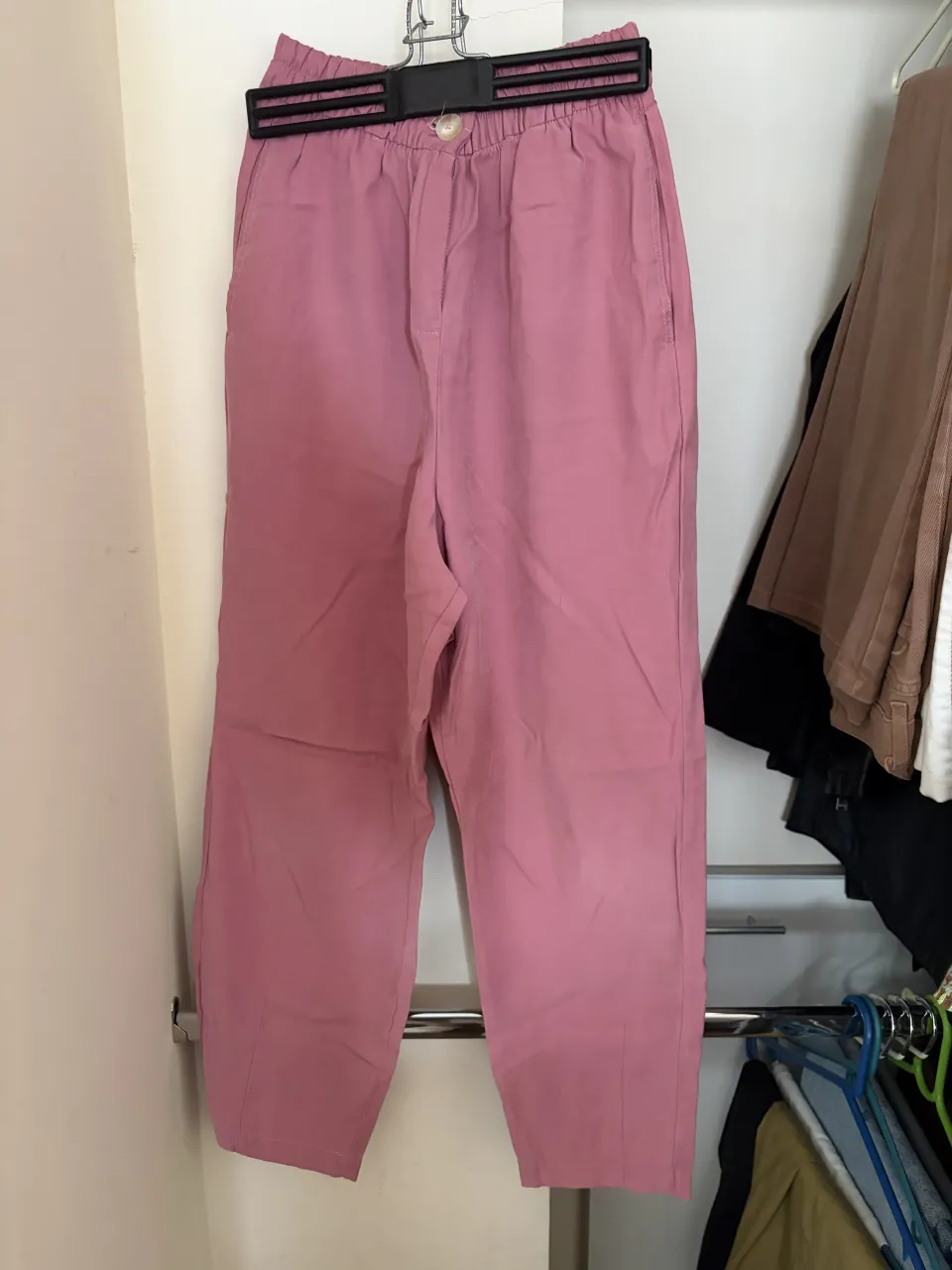 Pantalones de corte relajado en un suave tono rosa, ideales para un look cómodo y fresco. Cuentan con cintura elástica y un diseño práctico con bolsillos. Perfectos para combinar con una blusa o una remera para un estilo casual y desenfadado.