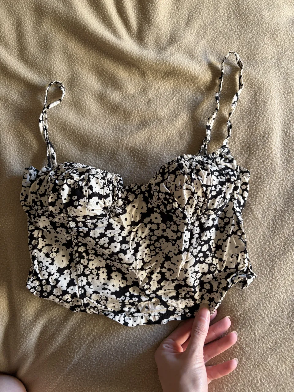 Top corto estampado floral blanco y negro, con tiras regulables y detalle de lazo en el frente. Ideal para un look canchero y fresco.