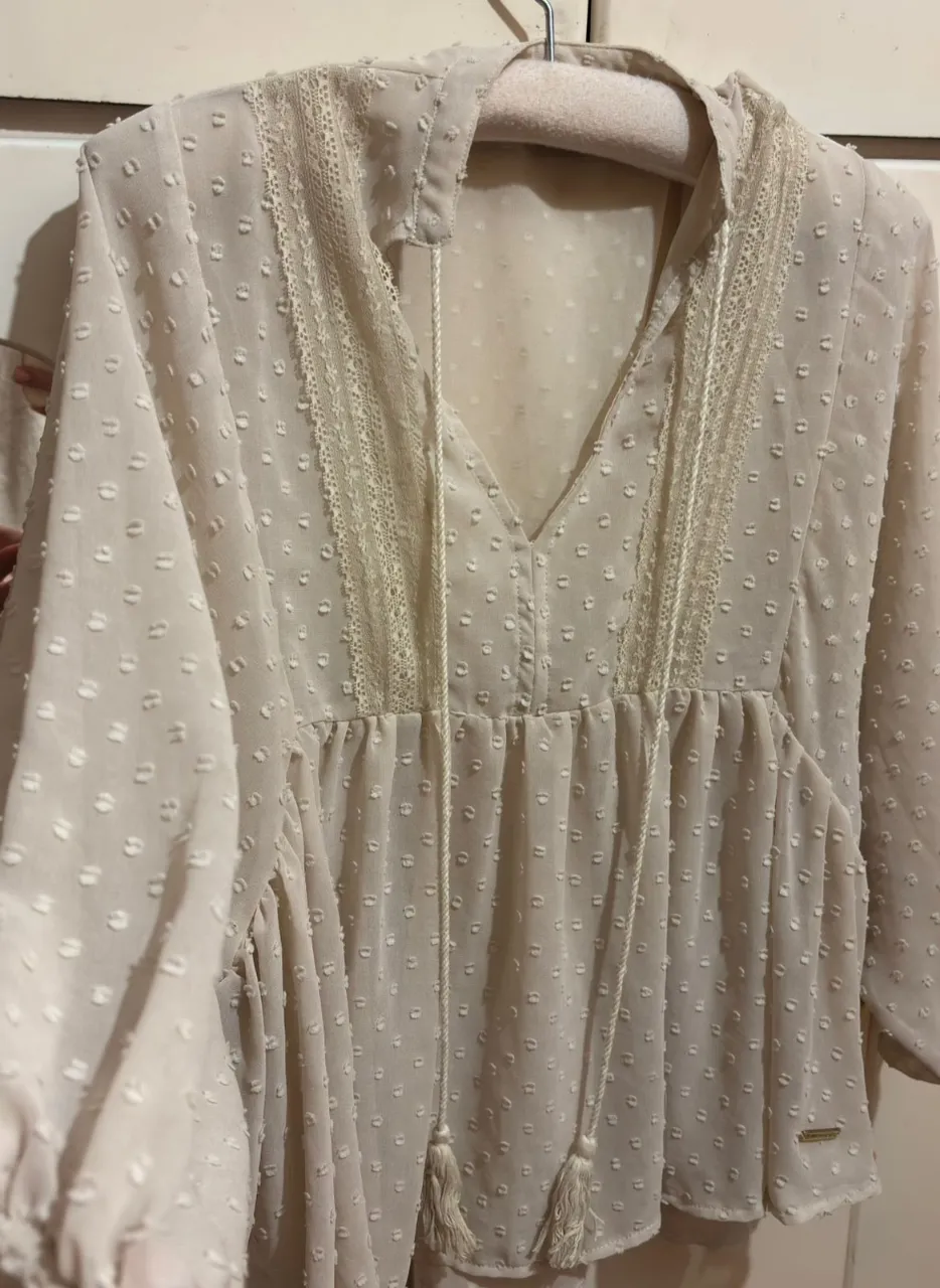 Camisa súper boho chic de gasa, con delicados detalles de encaje y bordado suizo.

Mangas no tan largas, escote en V con cordones y flecos. Corte suelto y vaporoso que estiliza y queda precioso puesto.

Romántica y muy combinable.