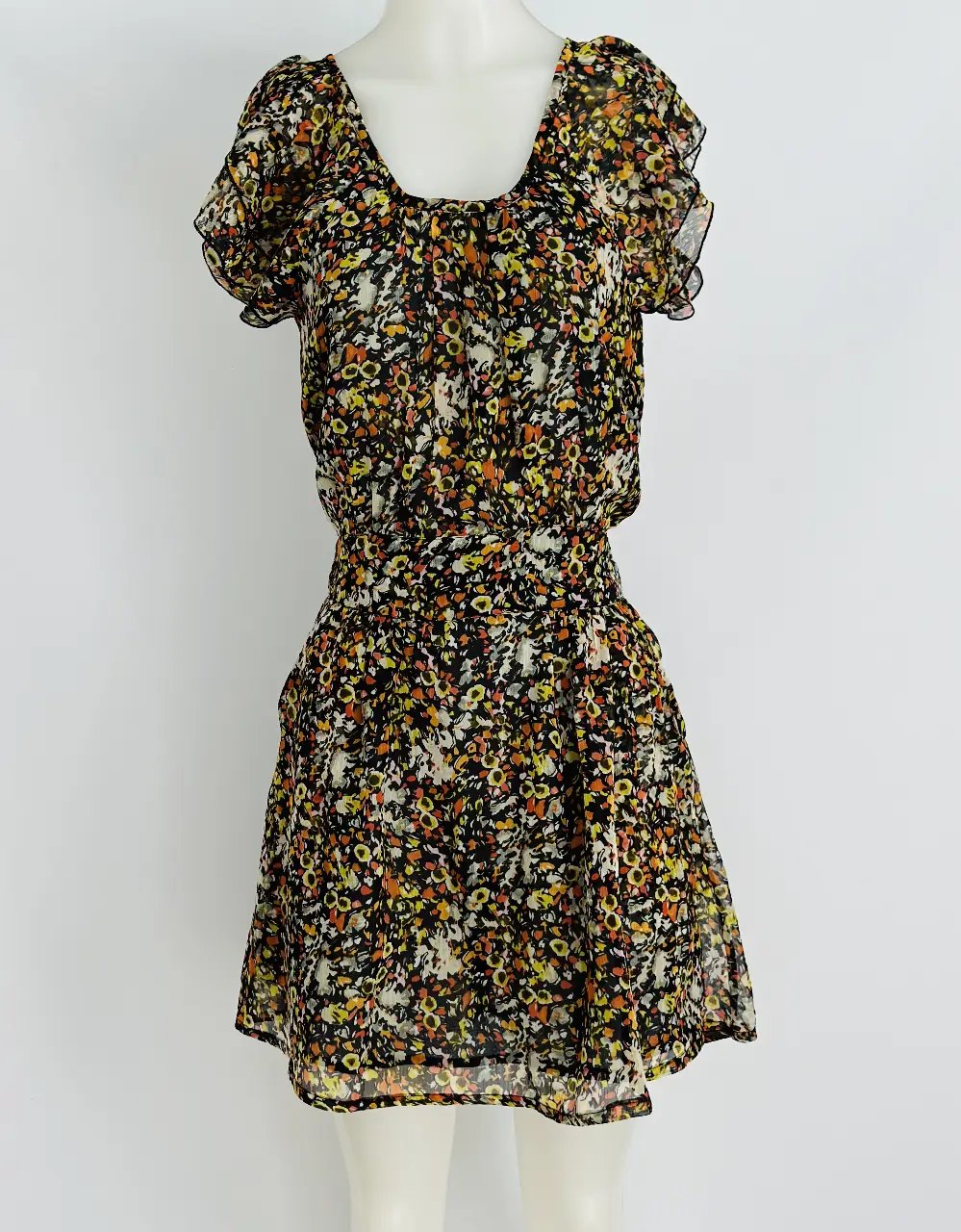 Vestido mini con estampado floral en tonos amarillos, naranjas y negros. Diseño con cintura marcada y mangas cortas con volados. Ideal para un look fresco y femenino.
