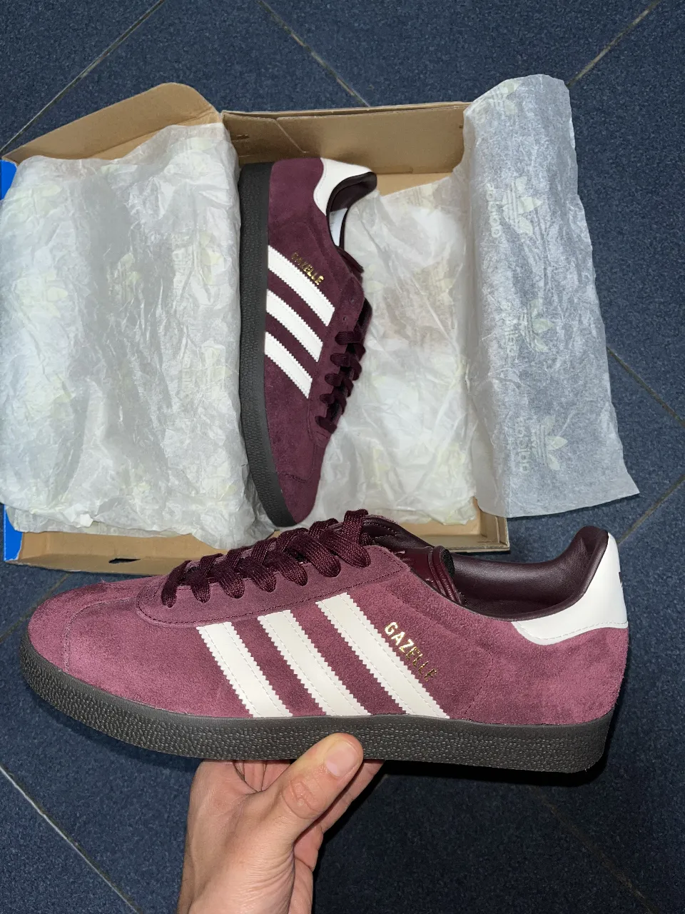 Zapatillas Adidas Gazelle en color borgoña con detalles en blanco. Un clásico del calzado deportivo, ideales para un look casual y cómodo.