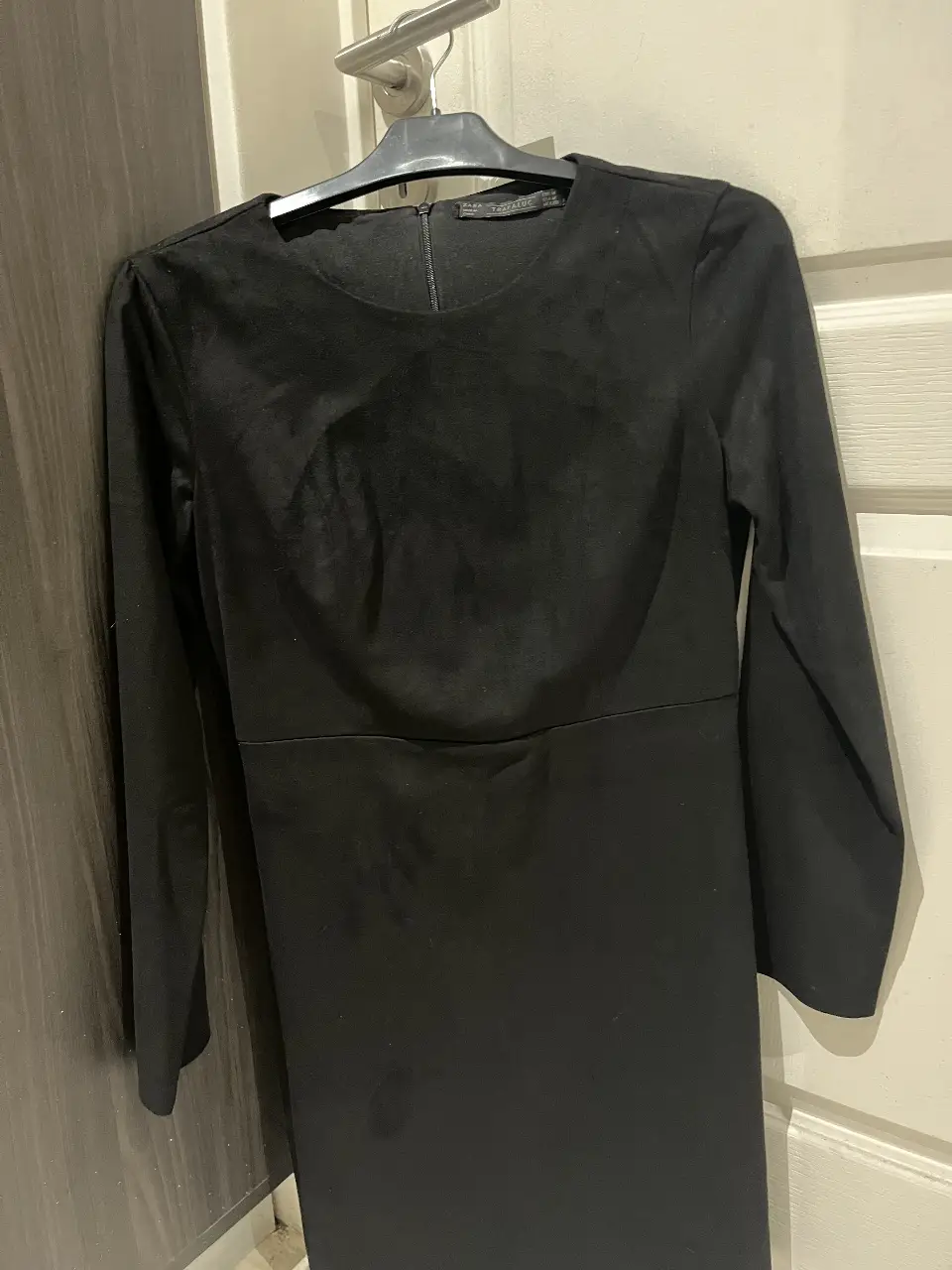 Vestido midi negro de tela similar a gamuza, con mangas largas y corte entallado. Ideal para eventos formales o salidas nocturnas.