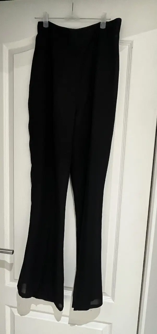 Pantalón sastrero de gasa semi-transparente negro de mujer, con corte de bota ancha. Talle 42.