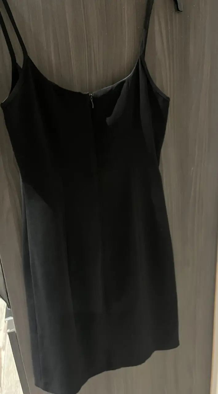 Vestido mini negro con tiras finas y cierre en la espalda. Ideal para una salida nocturna o evento especial.