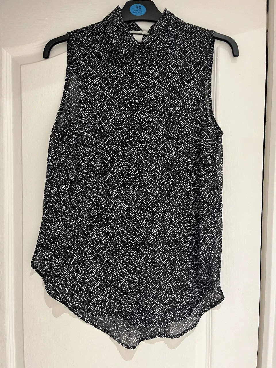 Blusa sin mangas semi transparente de H&M con estampado de lunares en blanco y negro. Ideal para un look casual y fresco.