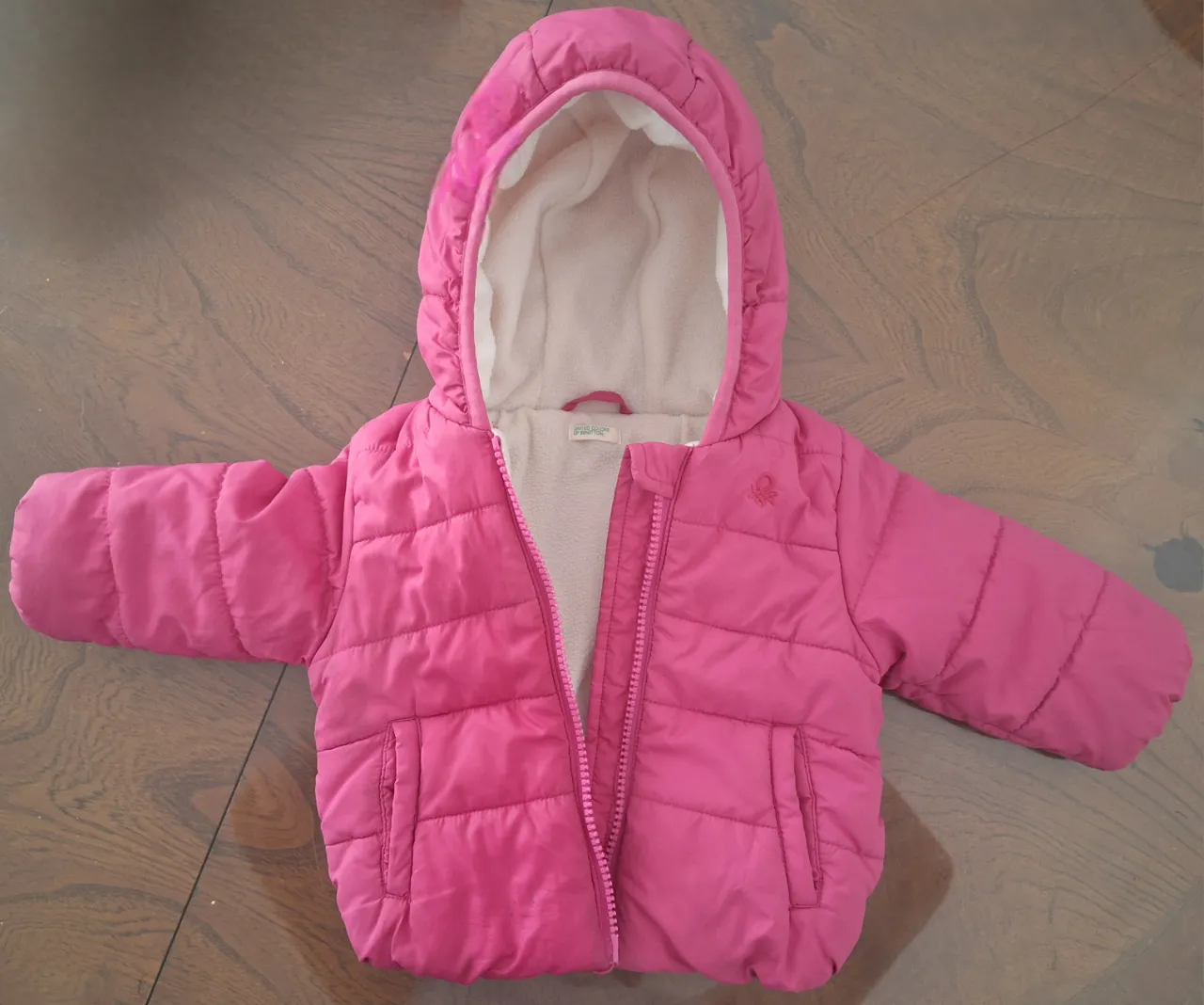 Abrigo acolchado súper calentito para nena, color rosa vibrante. Tiene capucha forrada en polar y cierre completo. Ideal para los días fríos.