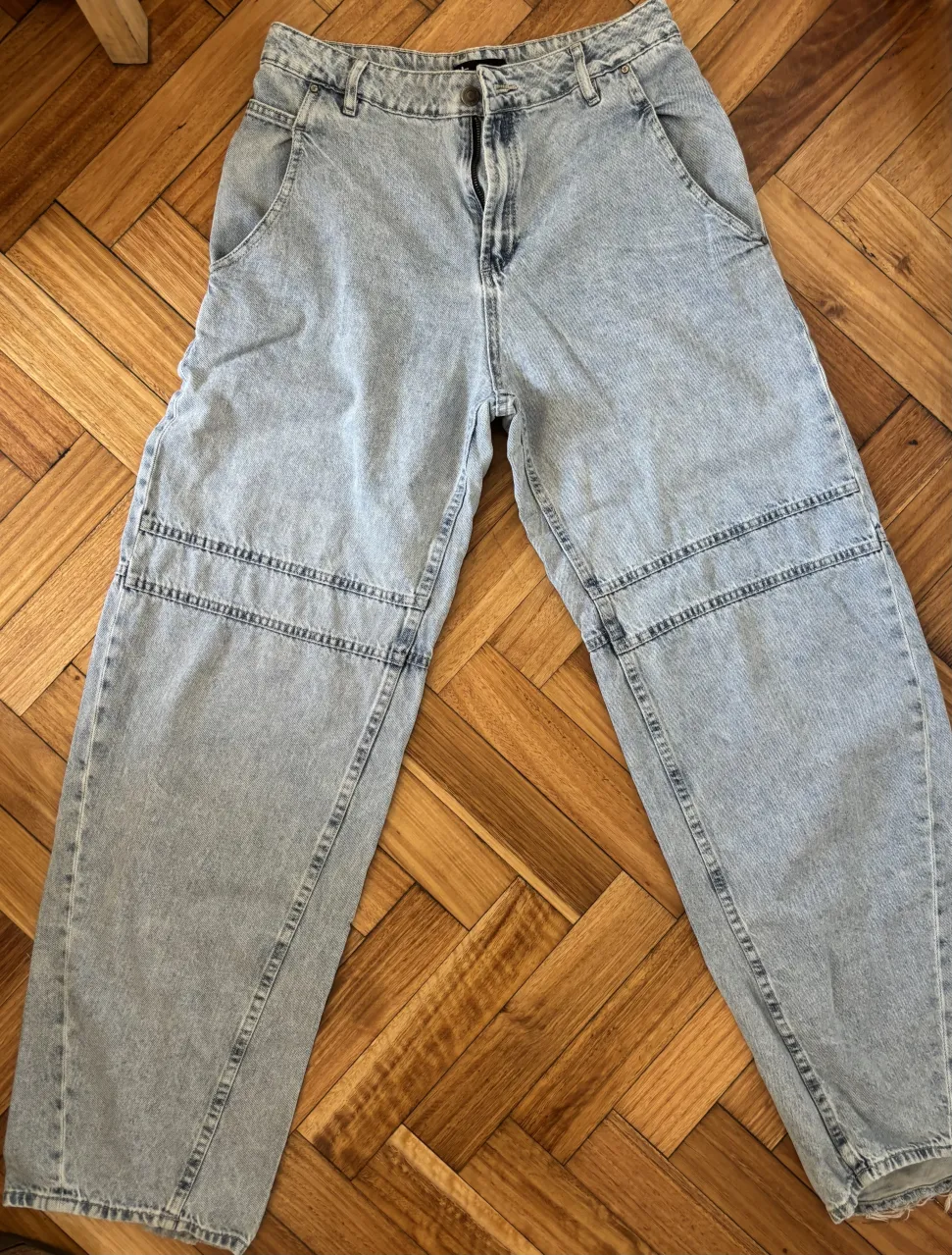 Jean de tiro medio, corte ancho, con detalles de costura en las rodillas. 