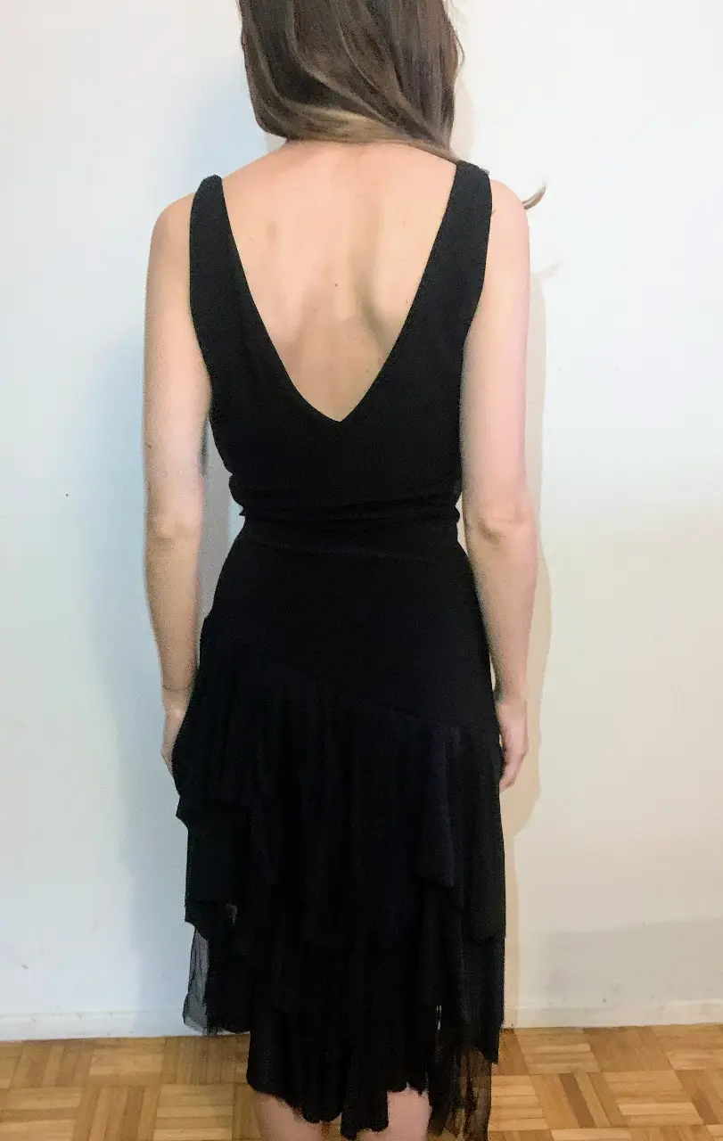 Vestido midi negro con escote en V y falda con volados. Ideal para eventos formales o fiestas.