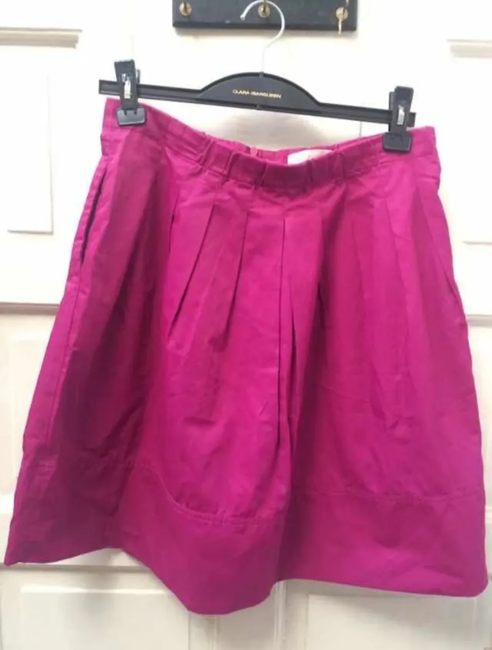 Pollera Clara Ibarguren  corta fucsia con tablas y bolsillos. Ideal para un look canchero y fresco.