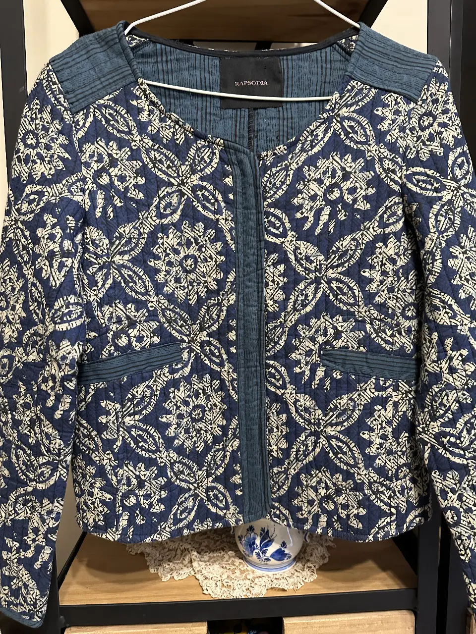 Campera acolchada de mujer con estampado floral en tonos azul y blanco. Diseño con cierre frontal, bolsillos y detalles en azul liso. Ideal para un look casual y abrigado.