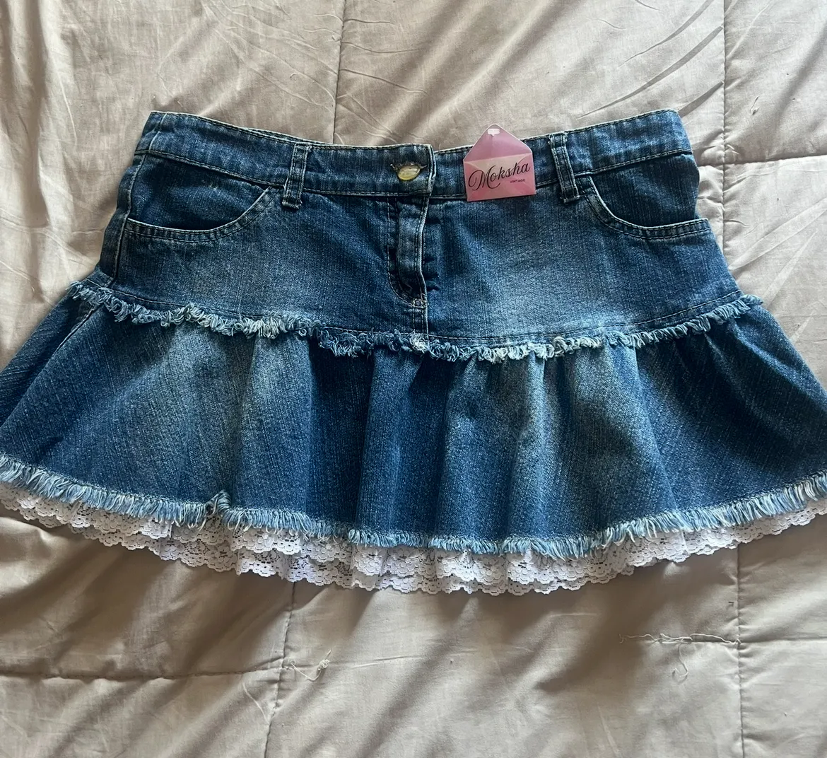 Pollera de jean tiro alto talle 38/40 con detalles de encaje y volados. Un modelo súper canchero y con un toque Y2K que no puede faltar en tu guardarropa. Ideal para combinar con tops o remeras básicas. ES VINTAGE!! La compré second hand tiene la etiqueta no la usé!