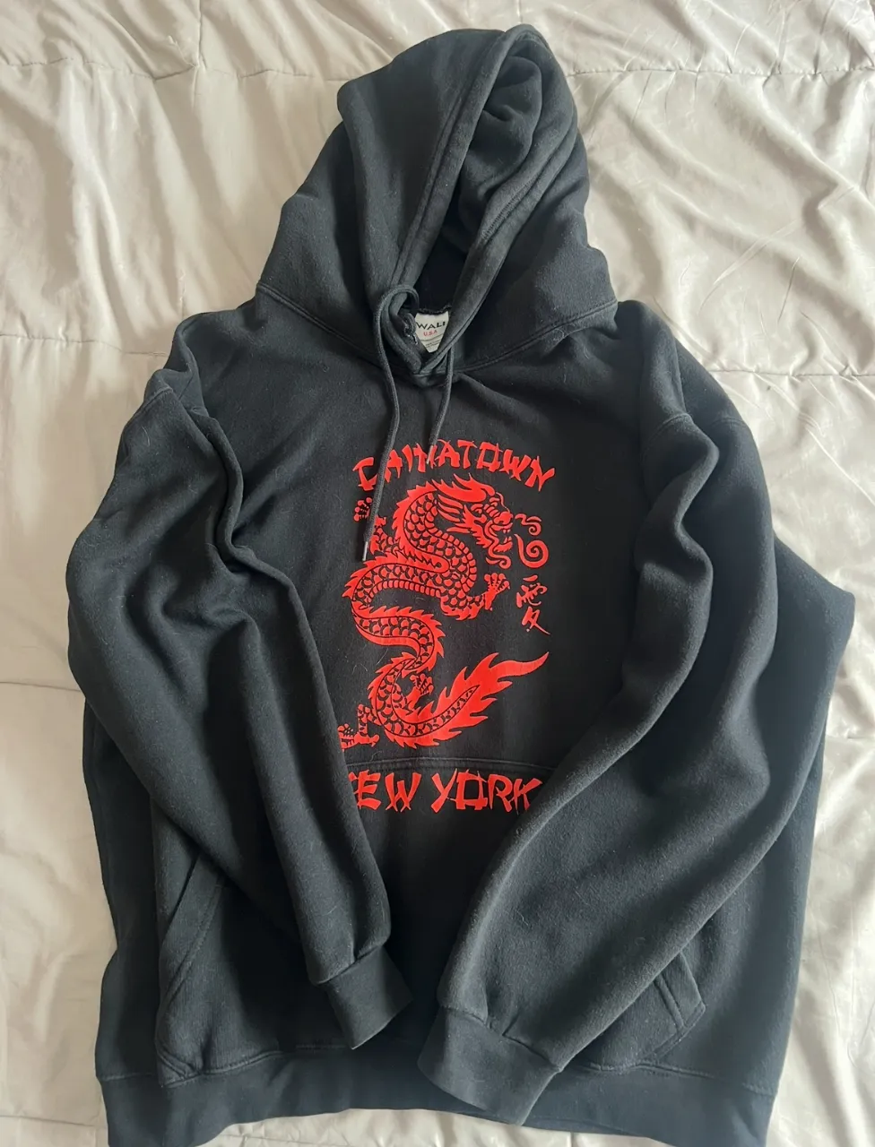 Buzo negro con capucha y estampa de dragón rojo y "Chinatown New York" en el frente. Ideal para un look urbano y canchero. es de una marca de ny y es talle m/l