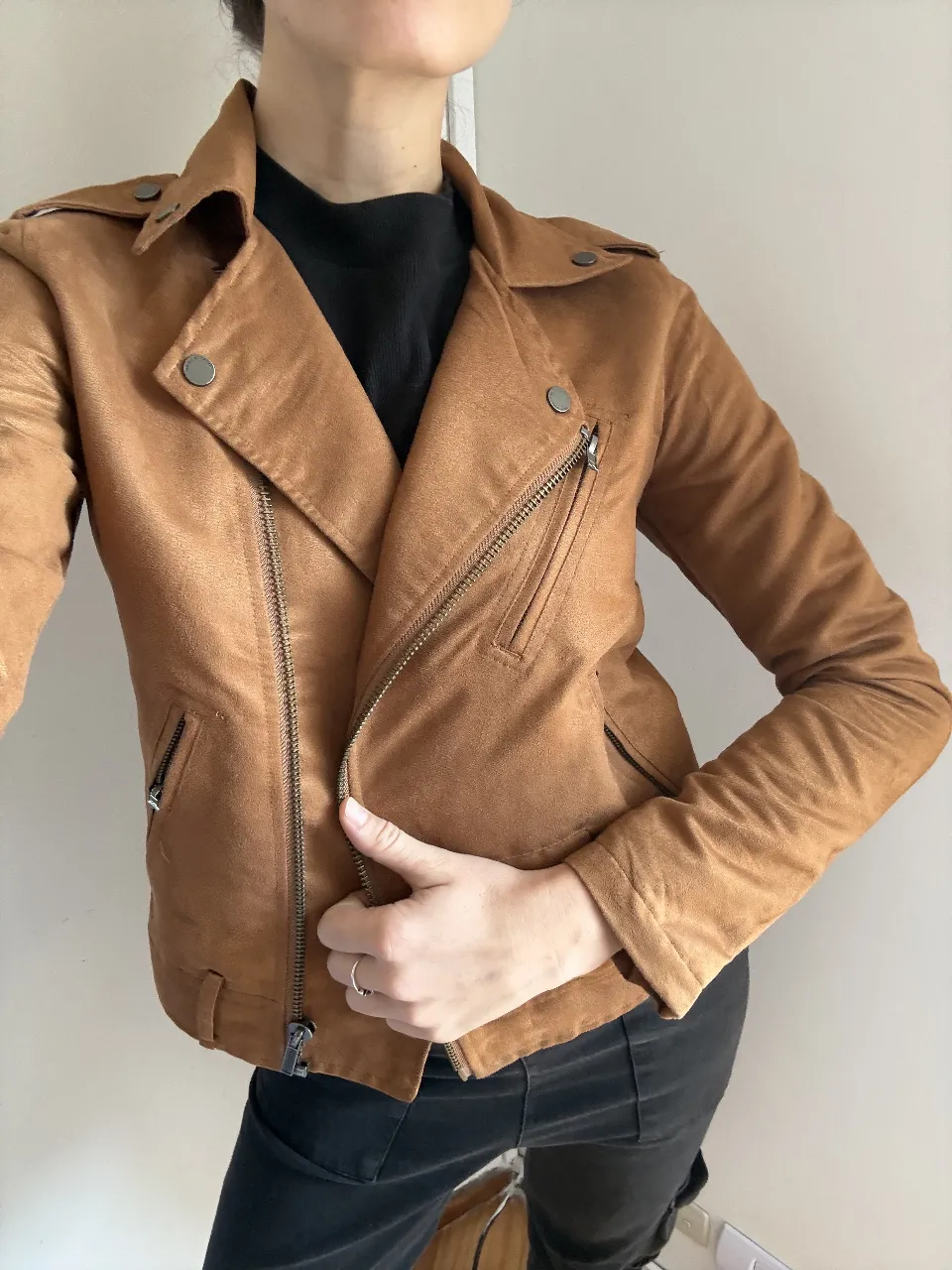 Campera estilo "biker" de gamuza sintética en color marrón. Diseño moderno con cierre cruzado, bolsillos con cierre y solapas. Ideal para un look canchero y con actitud.