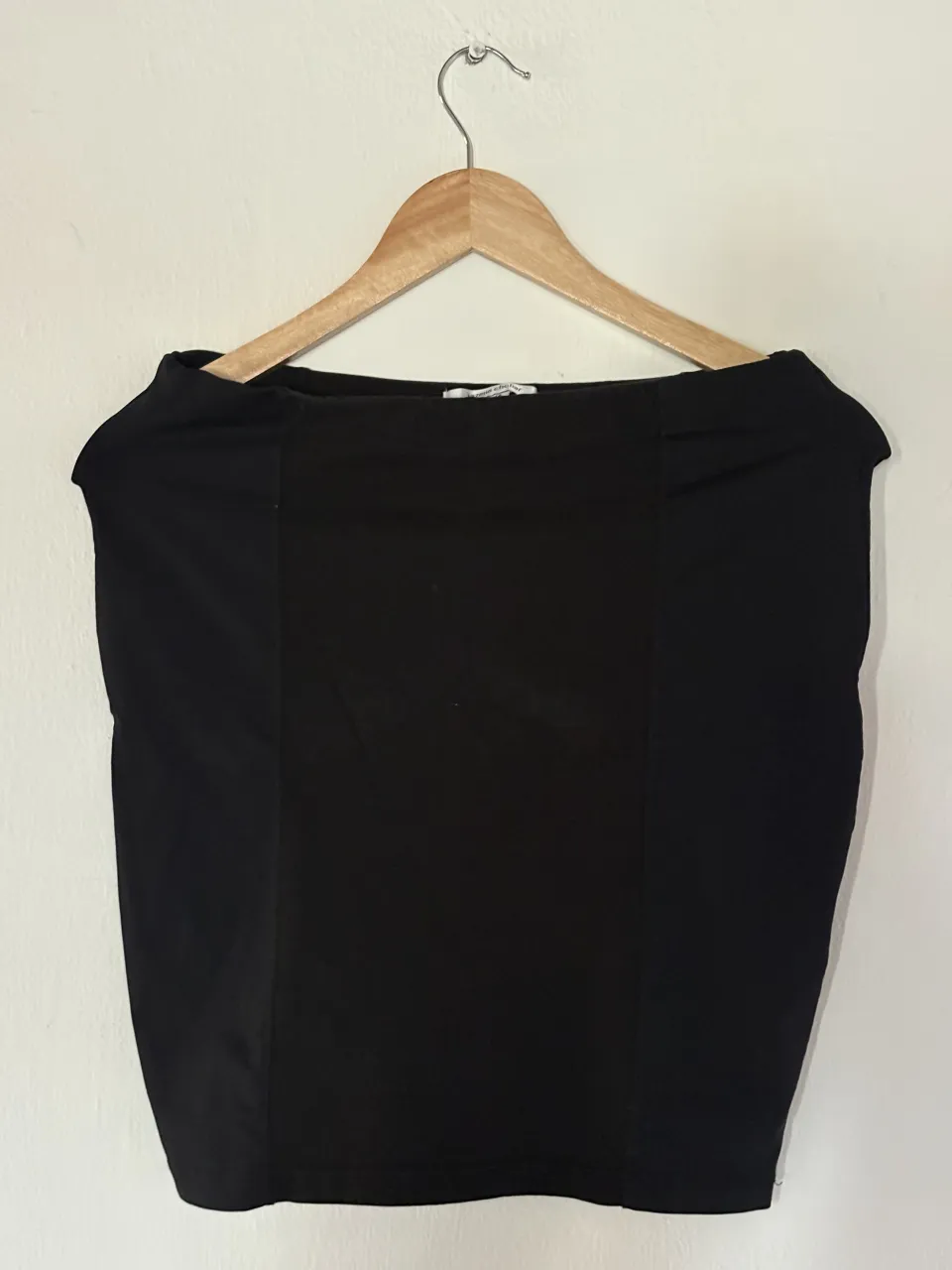 Pollera negra tiro alto, con un corte recto y moderno. Ideal para un look elegante o casual.