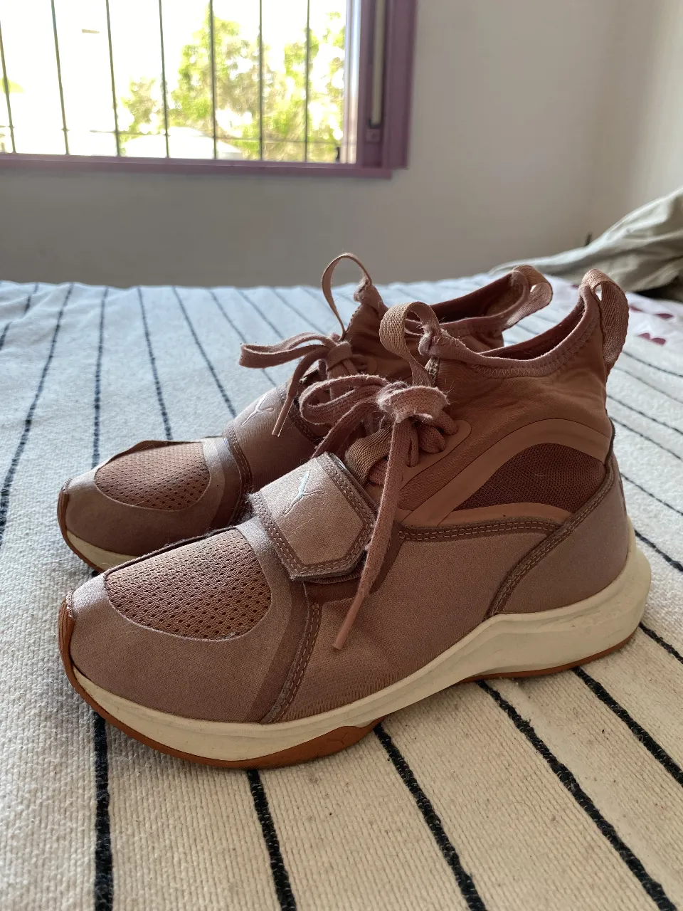 Zapatillas deportivas Puma color rosa pálido, ideales para entrenar o para un look casual. Tienen un diseño moderno con ajuste de velcro y cordones. ¡Perfectas para tus actividades!