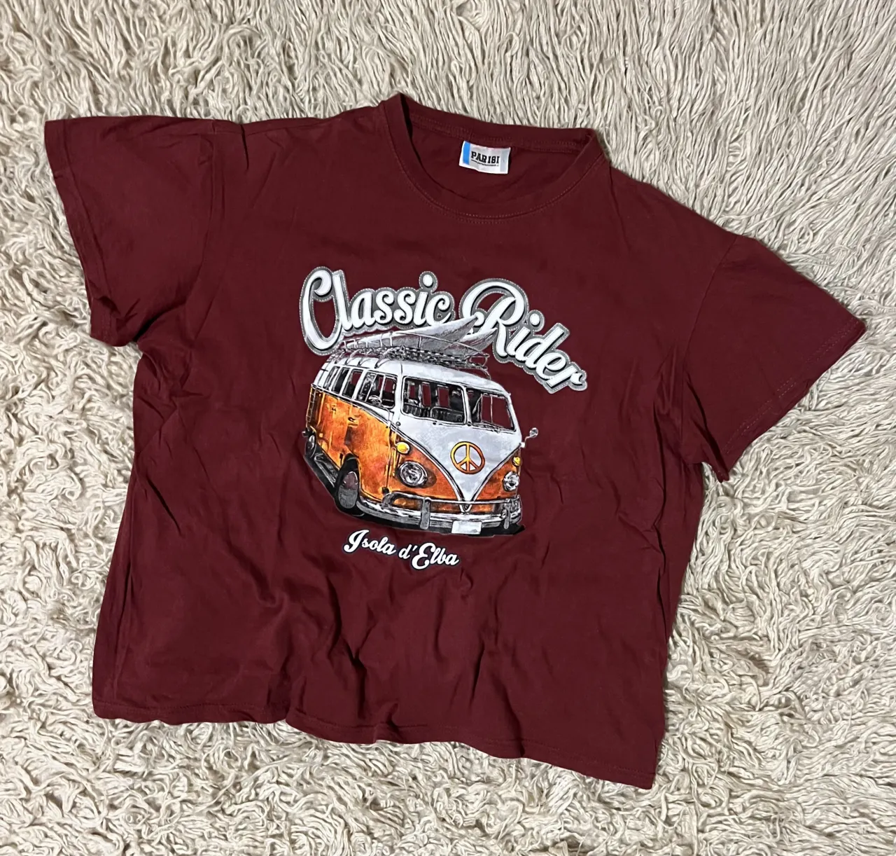 Remera de manga corta color bordó con estampa de una combi "Classic Rider" y "Isola d'Elba". Sisa 56 Cm - Largo 58 Cm 