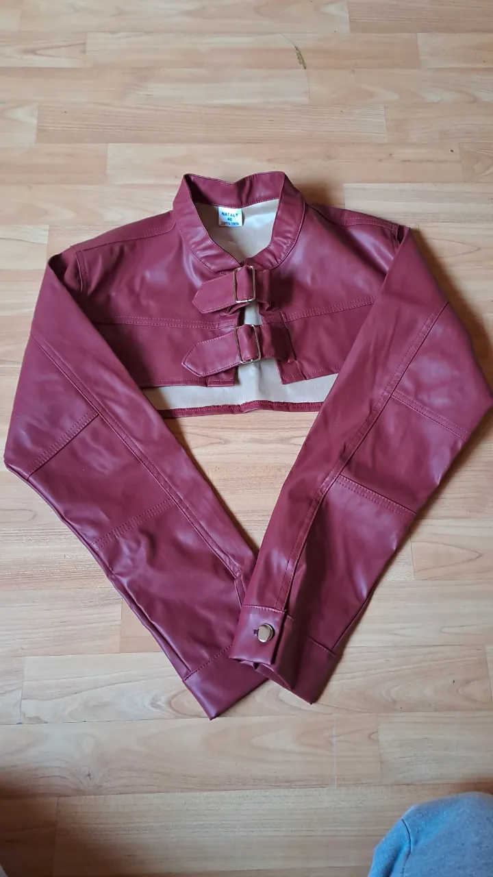 COMPLETAMENTE NUEVO. CHALECO SIN USAR NI UNA VEZ.
Chaqueta corta y canchera de cuero sintético color bordo/rojo con detalles de costura y hebillas. Ideal para un look moderno y audaz.
Excelente para una salida de noche con amigos. 
JAMAS LO USE Y ACABO DE COMPRARLO.